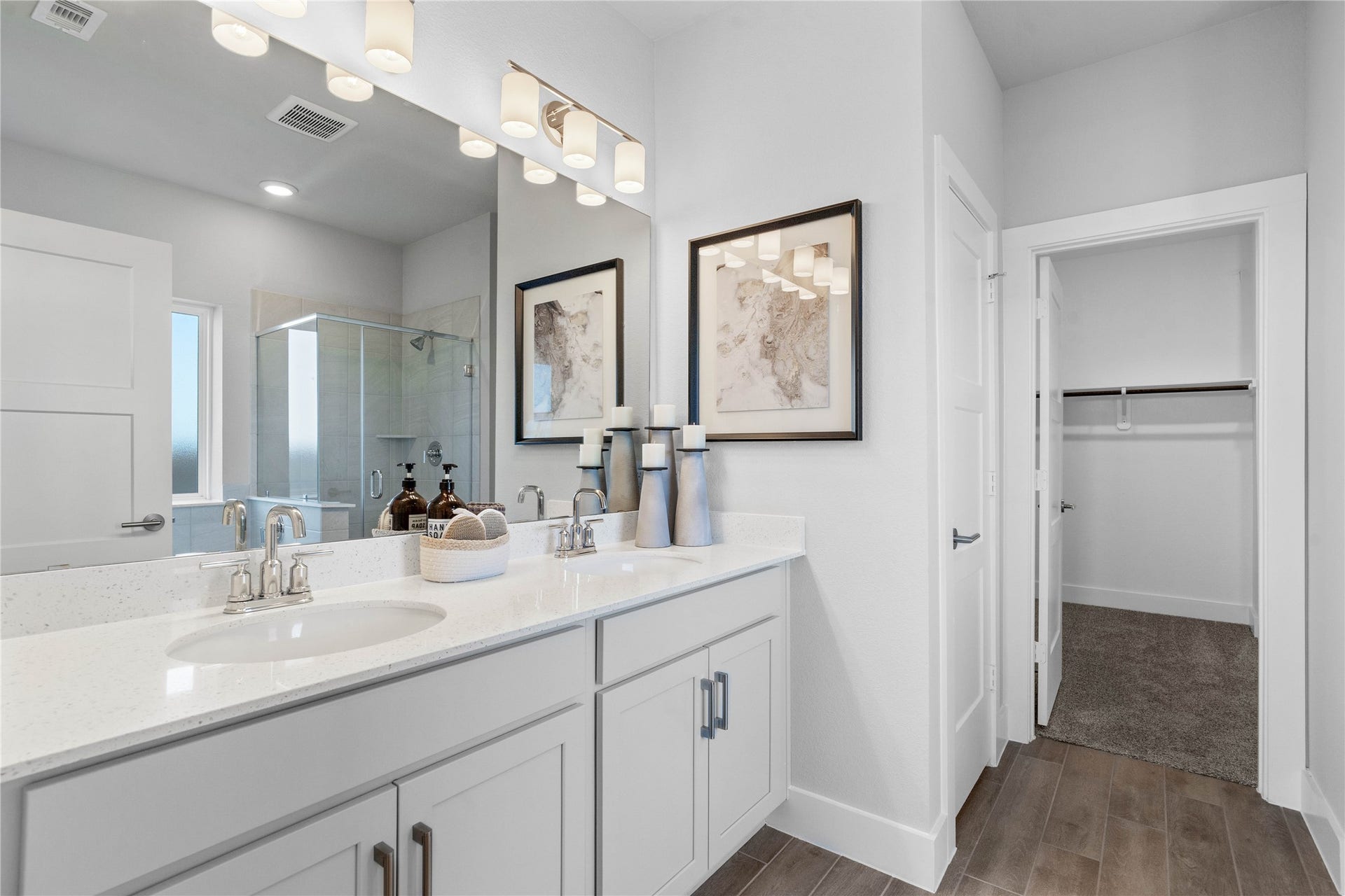 19608 Montgomery Ridge Way, Montgomery, TX 77316 A bright and functional primary bath offering dual sinks for busy mornings, a large mirror, soaking tub, and a modern glass-enclosed shower, creating a serene and efficient space.