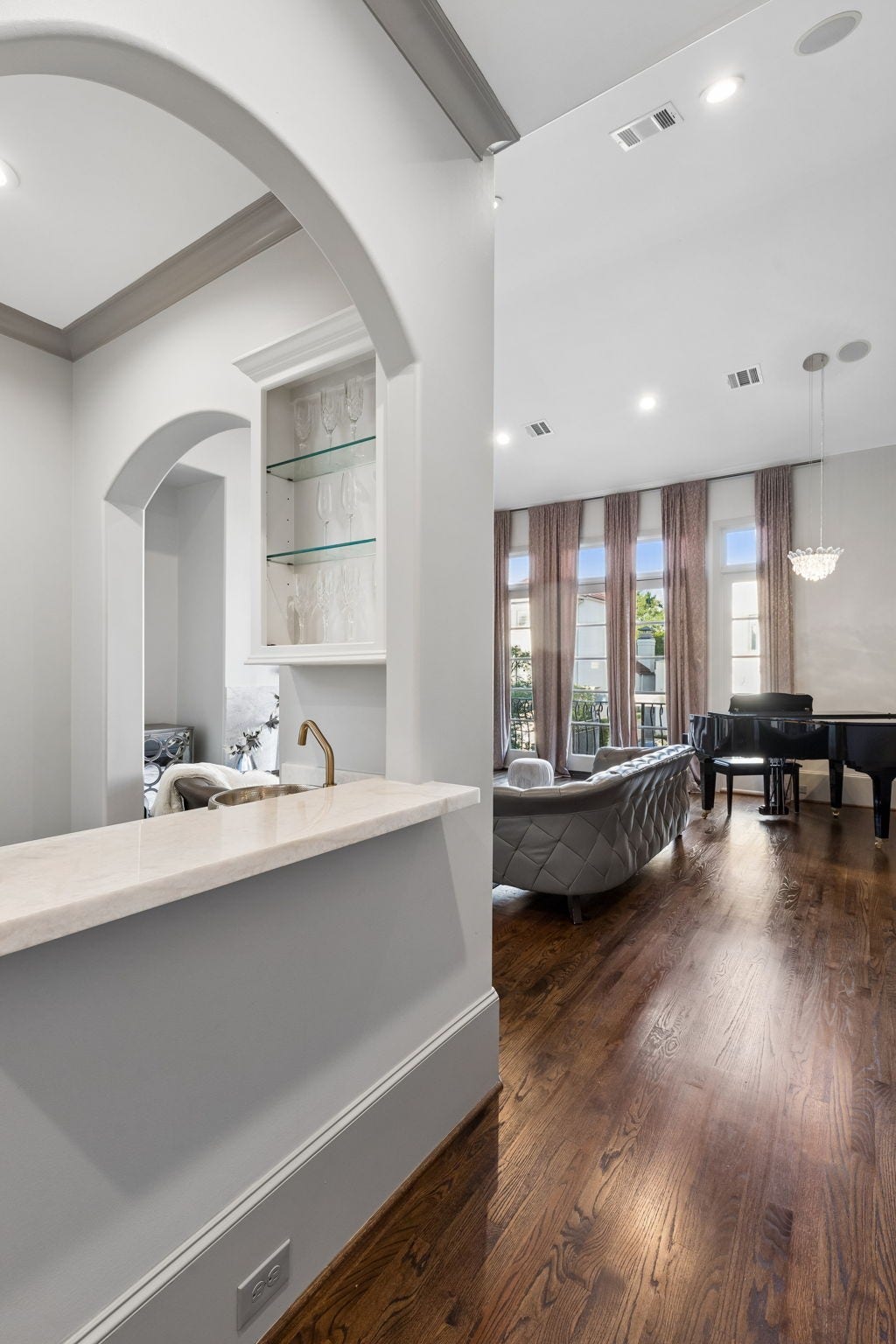 A stylish wet bar featuring hammered sink with a nickel finish, Quartzite countertop, Brizo brushed brass faucet, cabinets and Lanbopro beverage center.
