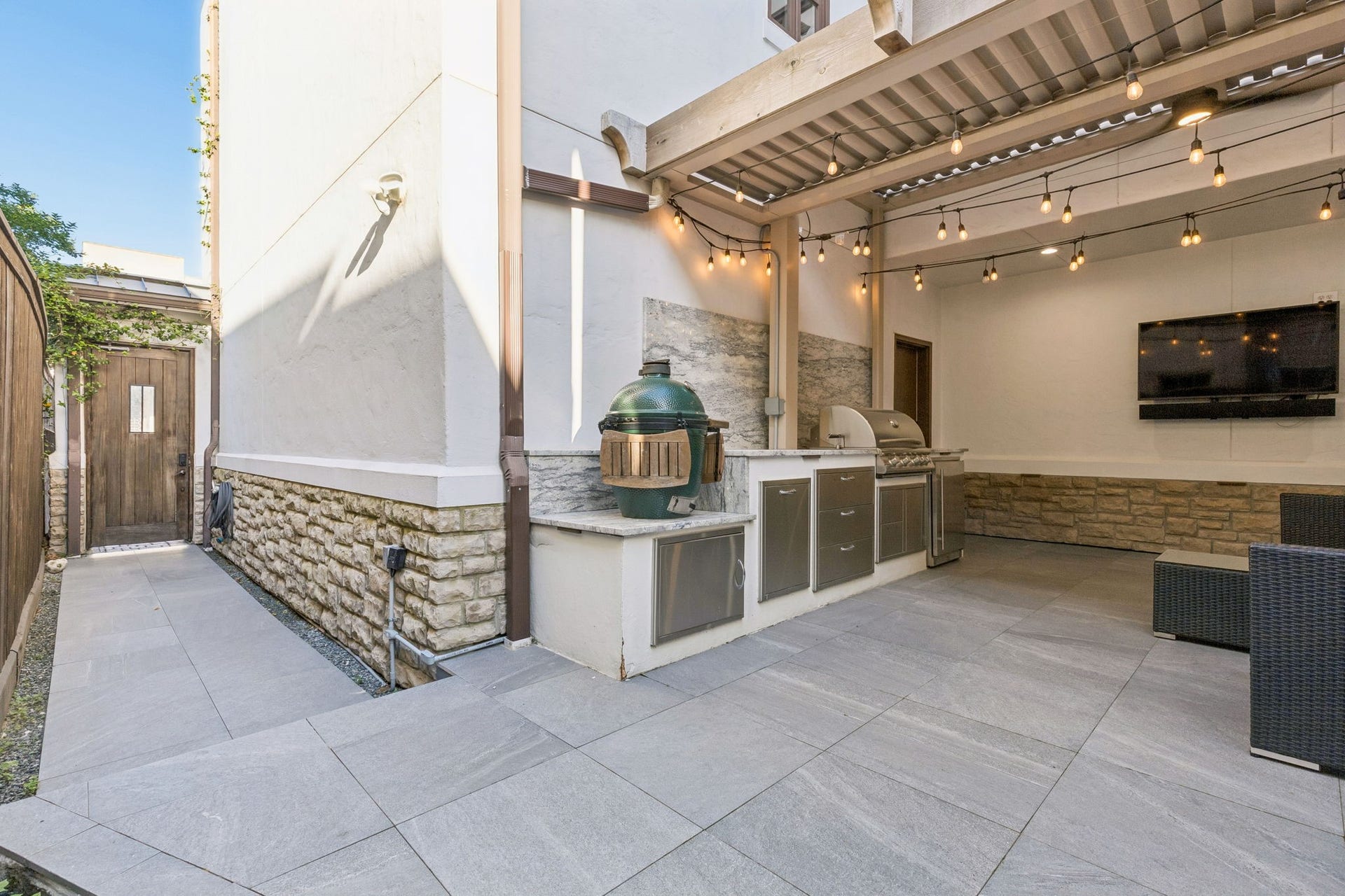 Designed for entertaining, the outdoor kitchen creates a seamless extension of the home's living spaces with a built-in Blackstone grill, Granite countertops and mini refrigerator that adds style and convenience to this outdoor retreat.