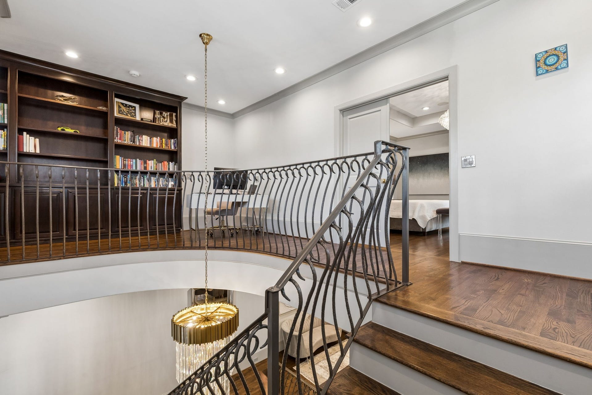 A versatile third-floor landing showcases custom built-in bookcases and cabinetry, with retained plumbing providing the opportunity to create a future wet bar or entertaining space. An inviting space that can easily serve as a reading nook, home office, or cozy lounge area.