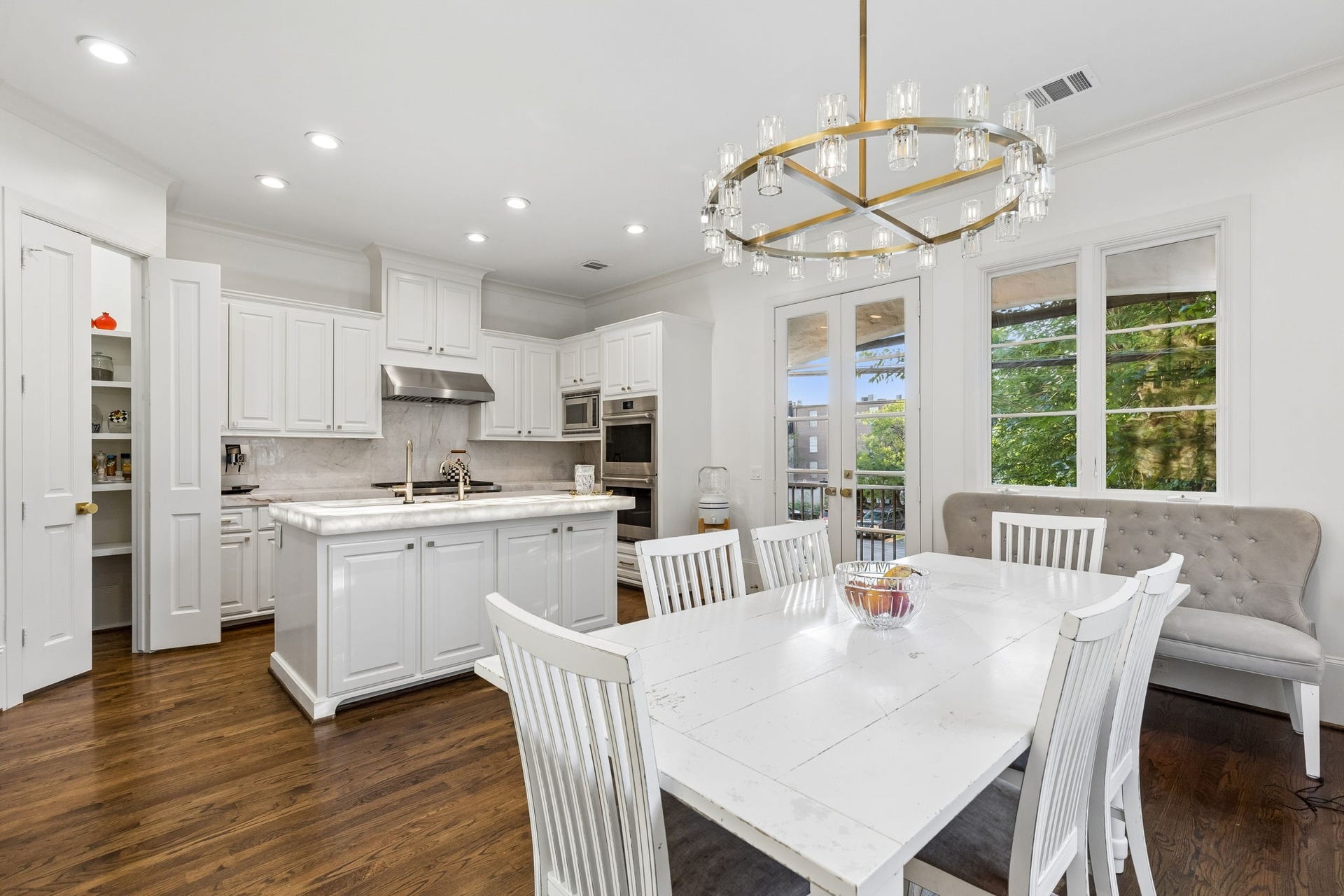 Quartzite countertops, a large illuminated Quartzite island, and a Sub-Zero refrigerator combine luxury, beauty, and functionality.