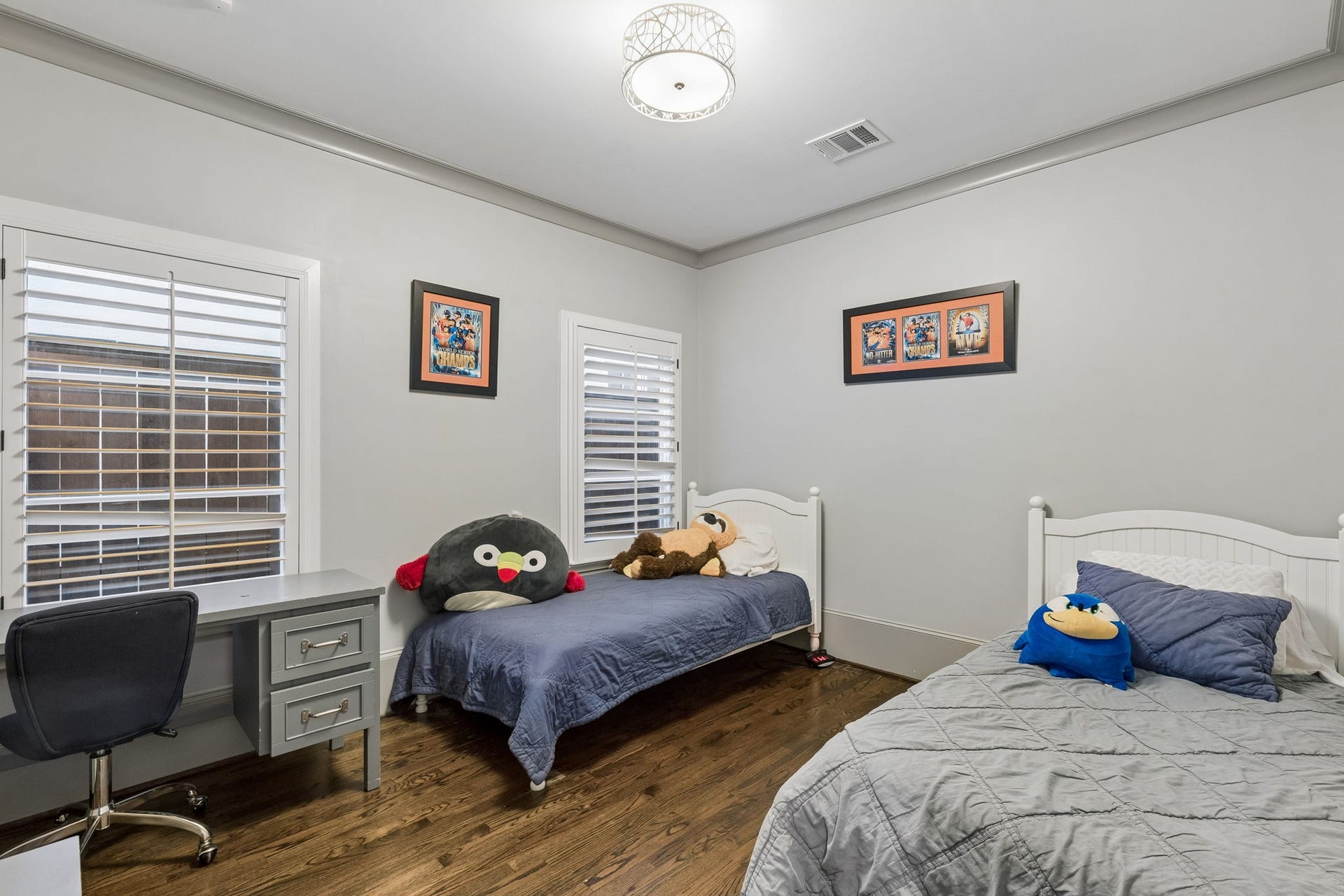 This secondary bedroom is adjacent to the other secondary bedroom and measures approximately 10'11" x 12'1". The bedroom is a comfortable and stylish retreat with a modern crystal drum chandelier that adds elegance to the room.