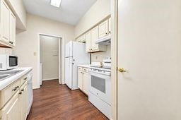 Bright and compact kitchen featuring white cabinetry, modern appliances, and wood flooring for a cozy cooking space.