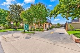 Charming gated entrance surrounded by lush greenery and a bright, welcoming atmosphere.