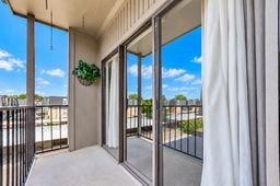 Charming balcony with sliding glass doors, offering an inviting outdoor space and scenic views.