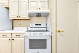 Charming kitchen with cream-colored cabinetry, a modern stove, and ample storage space, offering a clean and functional cooking area.