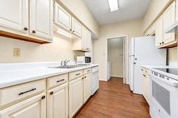 Bright and inviting galley kitchen with ample cabinetry, modern appliances, and warm wood flooring, ideal for culinary enthusiasts.
