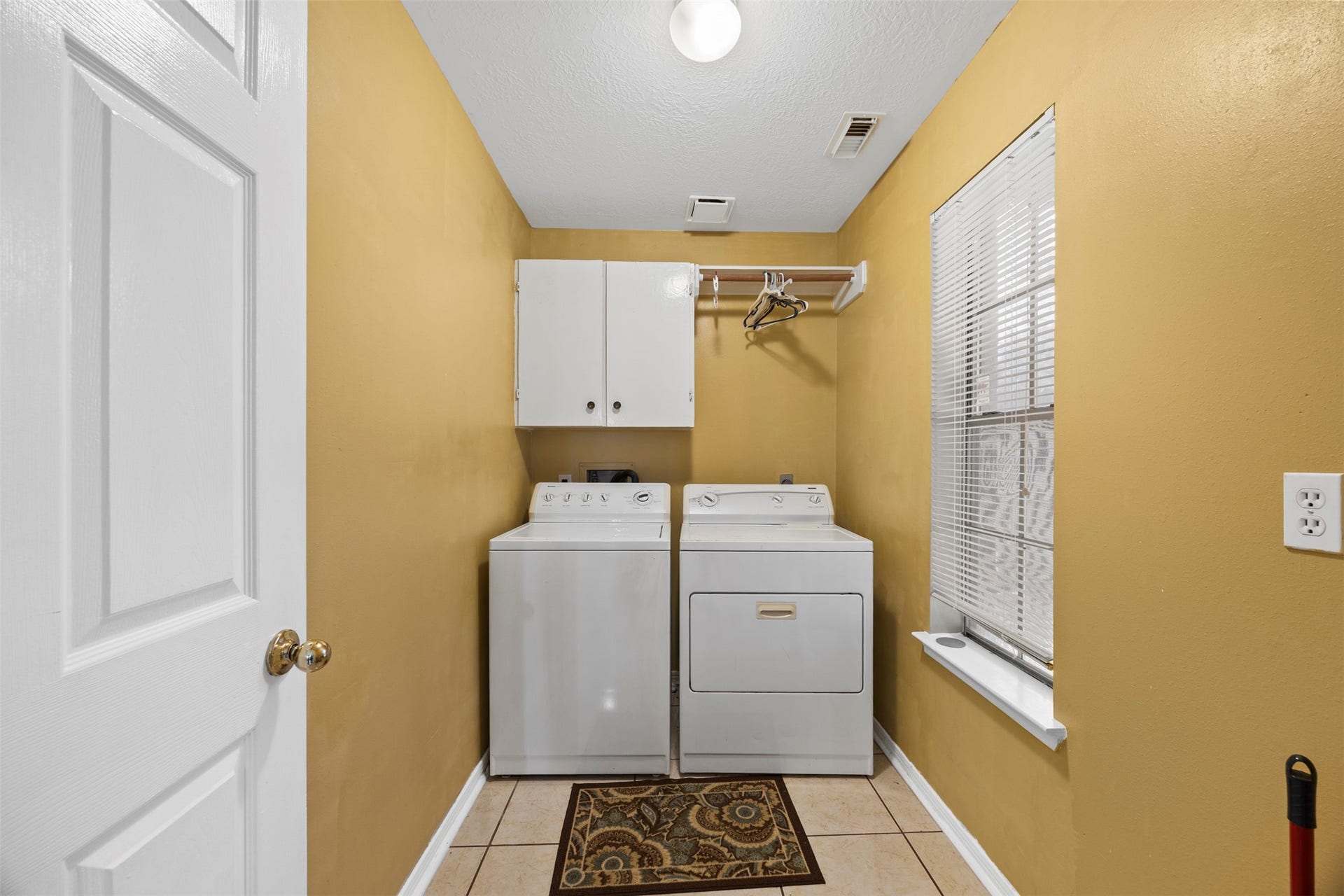 19119 Timber Trace Drive, Humble, TX 77346 Convenient laundry room with washer and dryer, ample storage, and a bright window for natural light.