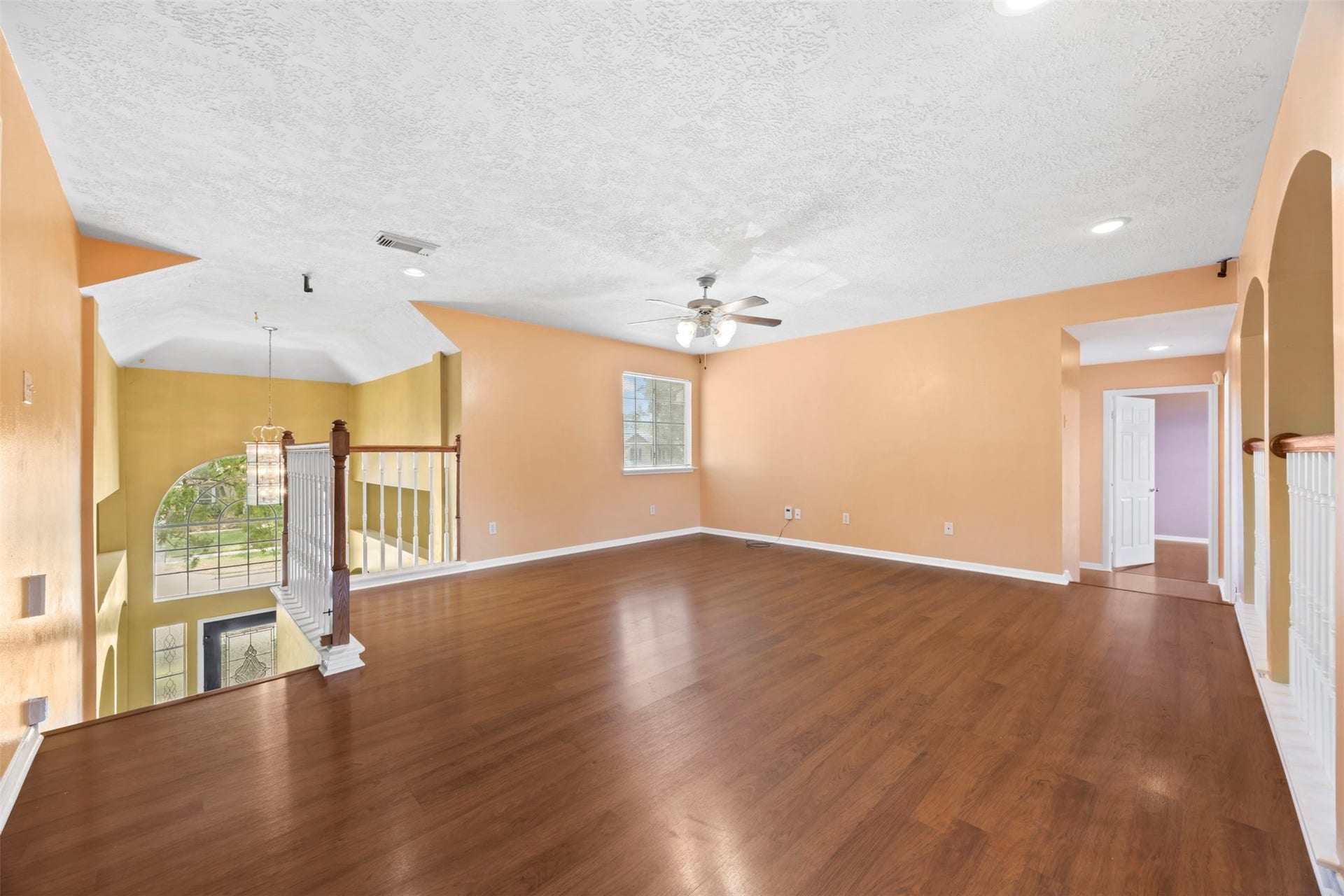 19119 Timber Trace Drive, Humble, TX 77346 Spacious open-concept living area with gleaming hardwood floors, a ceiling fan, and abundant natural light, perfect for entertaining or relaxing.