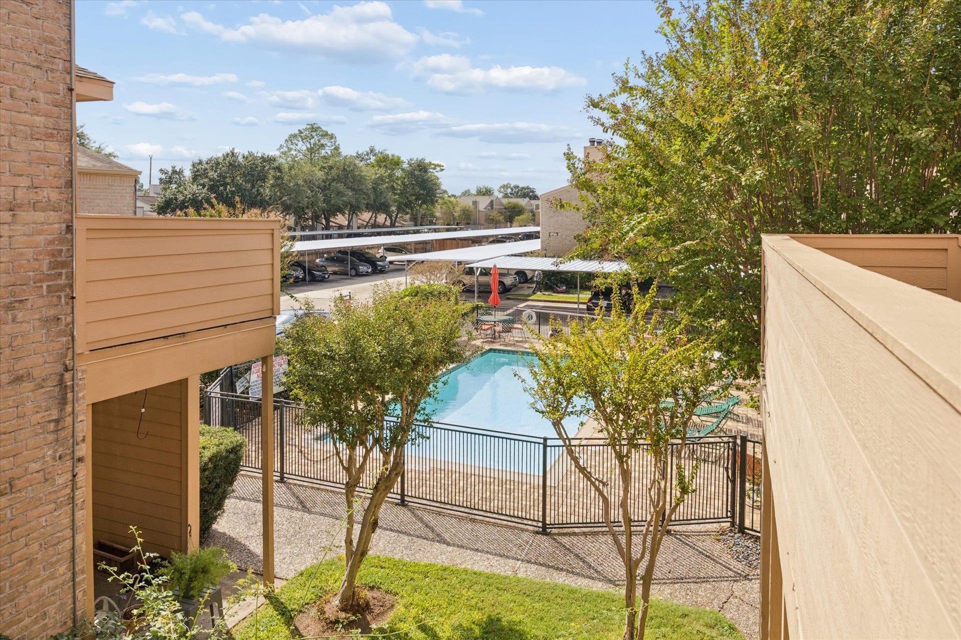 1915 Augusta Drive, #43, Houston, TX 77057 View from the unit overlooking the community pool and landscaped courtyard, creating a pleasant resort-style setting.