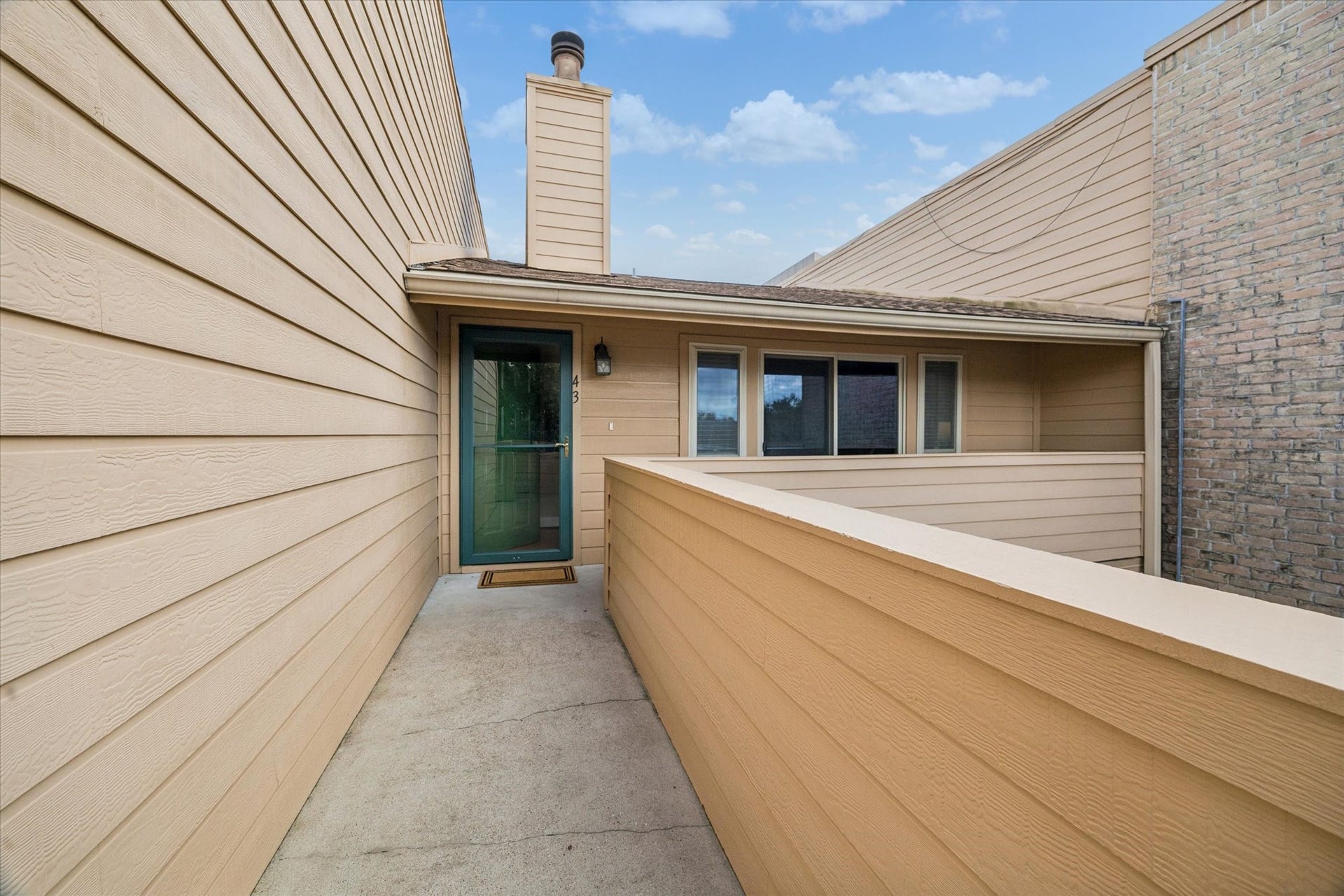 1915 Augusta Drive, #43, Houston, TX 77057 Exterior walkway leading to the unit, offering a private approach with an open-air setting and easy access to the second-floor residence.