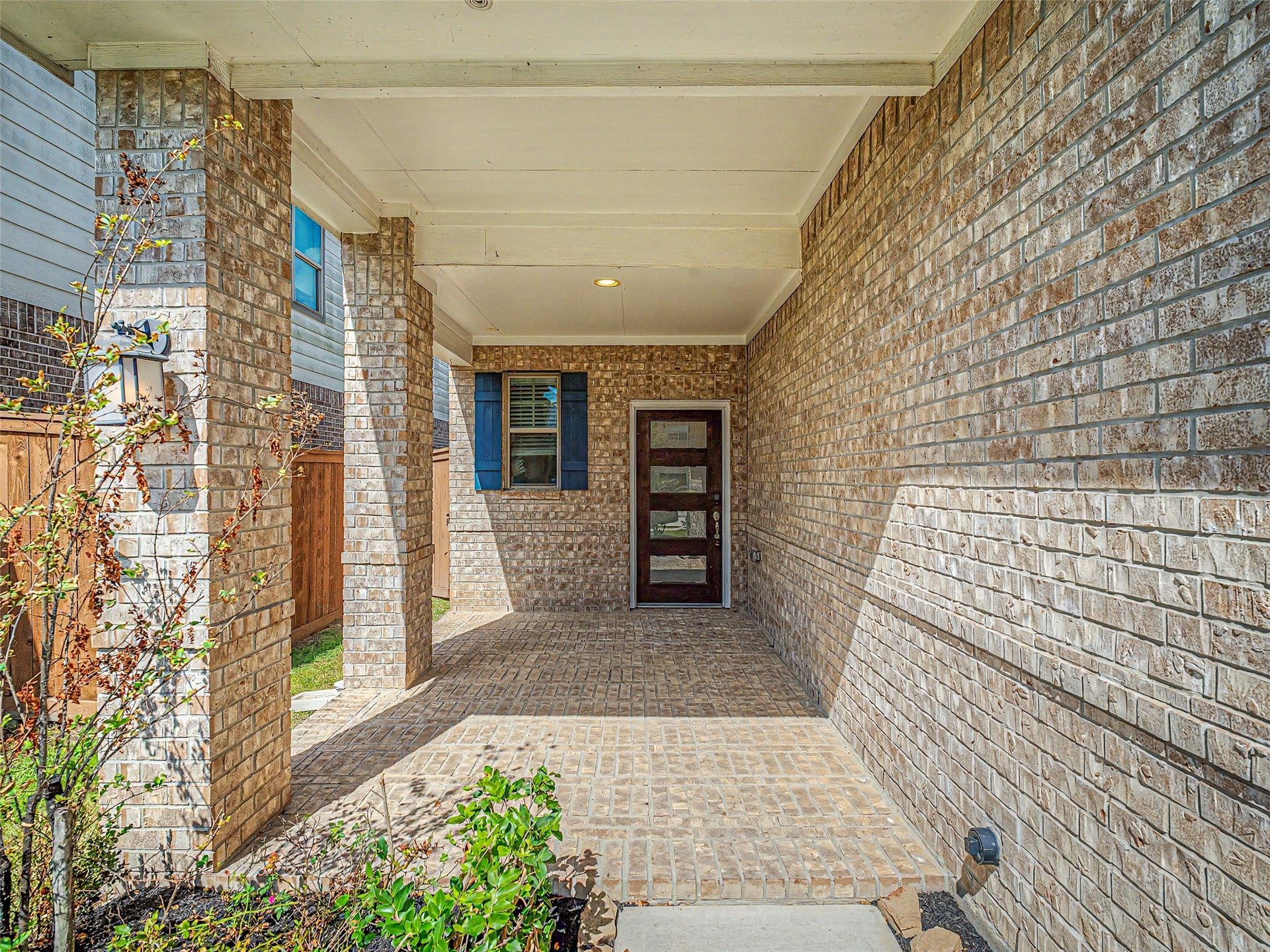 6019 Dovetail Cliff Court, Katy, TX 77493 Progressing toward the main entrance, you are welcomed by a private, shaded covered front porch. This welcoming entryway is framed by robust brick columns and solid brick walls, creating a distinct transition into the private residence.