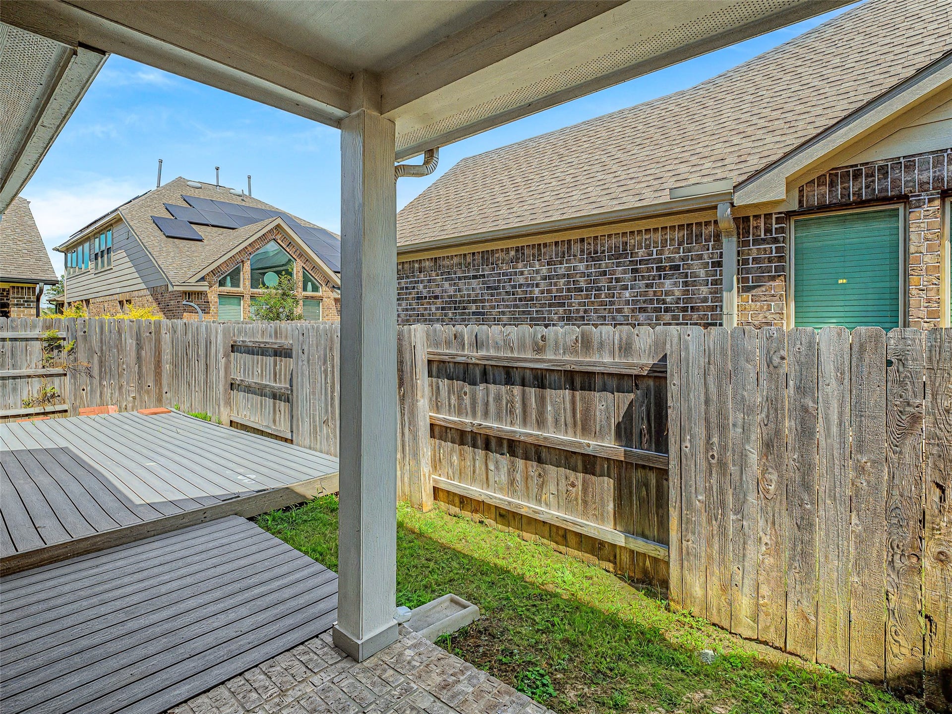 6019 Dovetail Cliff Court, Katy, TX 77493 This private outdoor space features a covered patio framed by solid support columns and brick paver flooring, providing a shaded spot to relax out of the sun.
