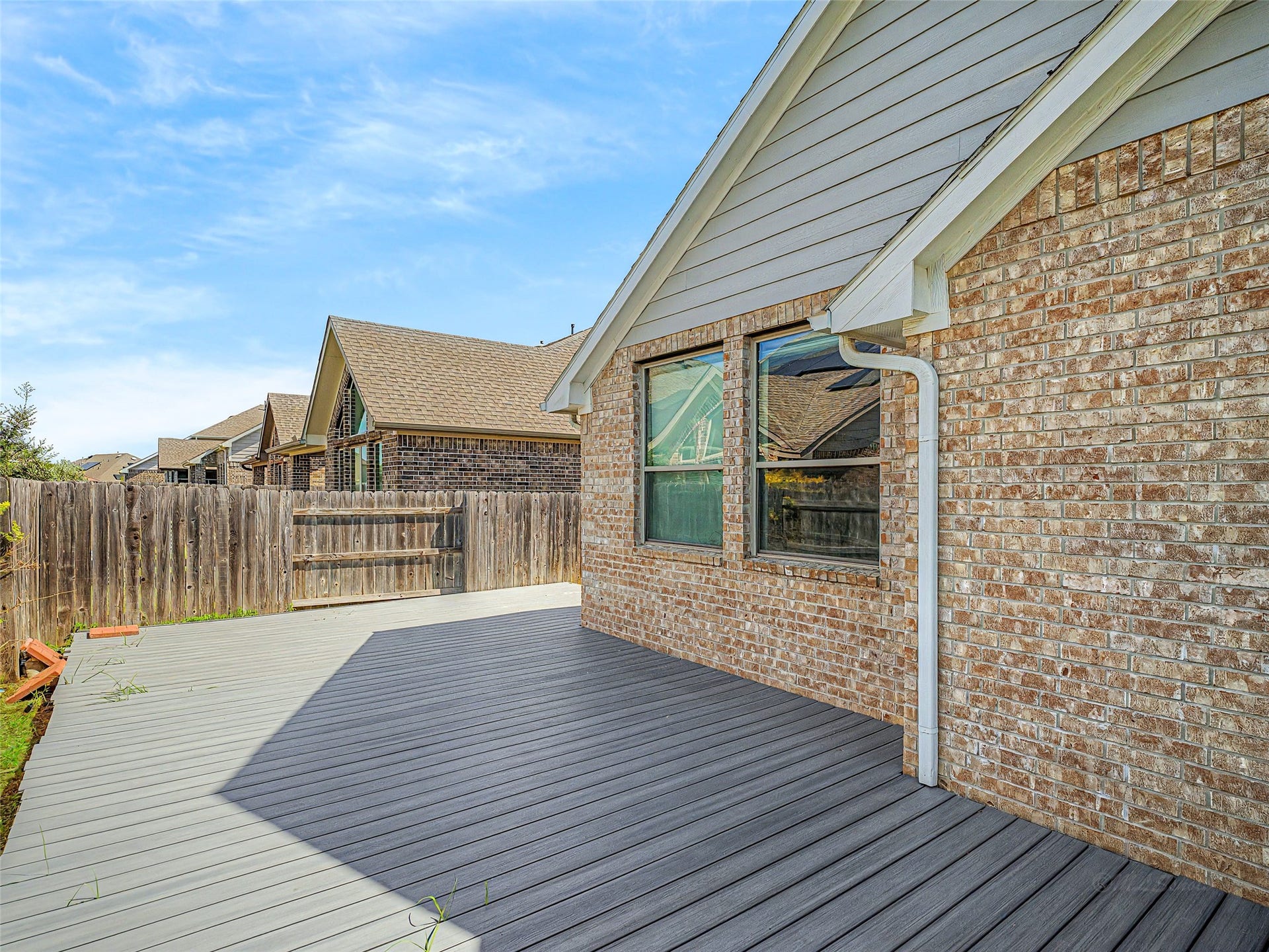 6019 Dovetail Cliff Court, Katy, TX 77493 Fully enclosed by a privacy fence, the yard combines low-maintenance decking with green lawn space, making it a functional outdoor retreat for relaxing or entertaining.