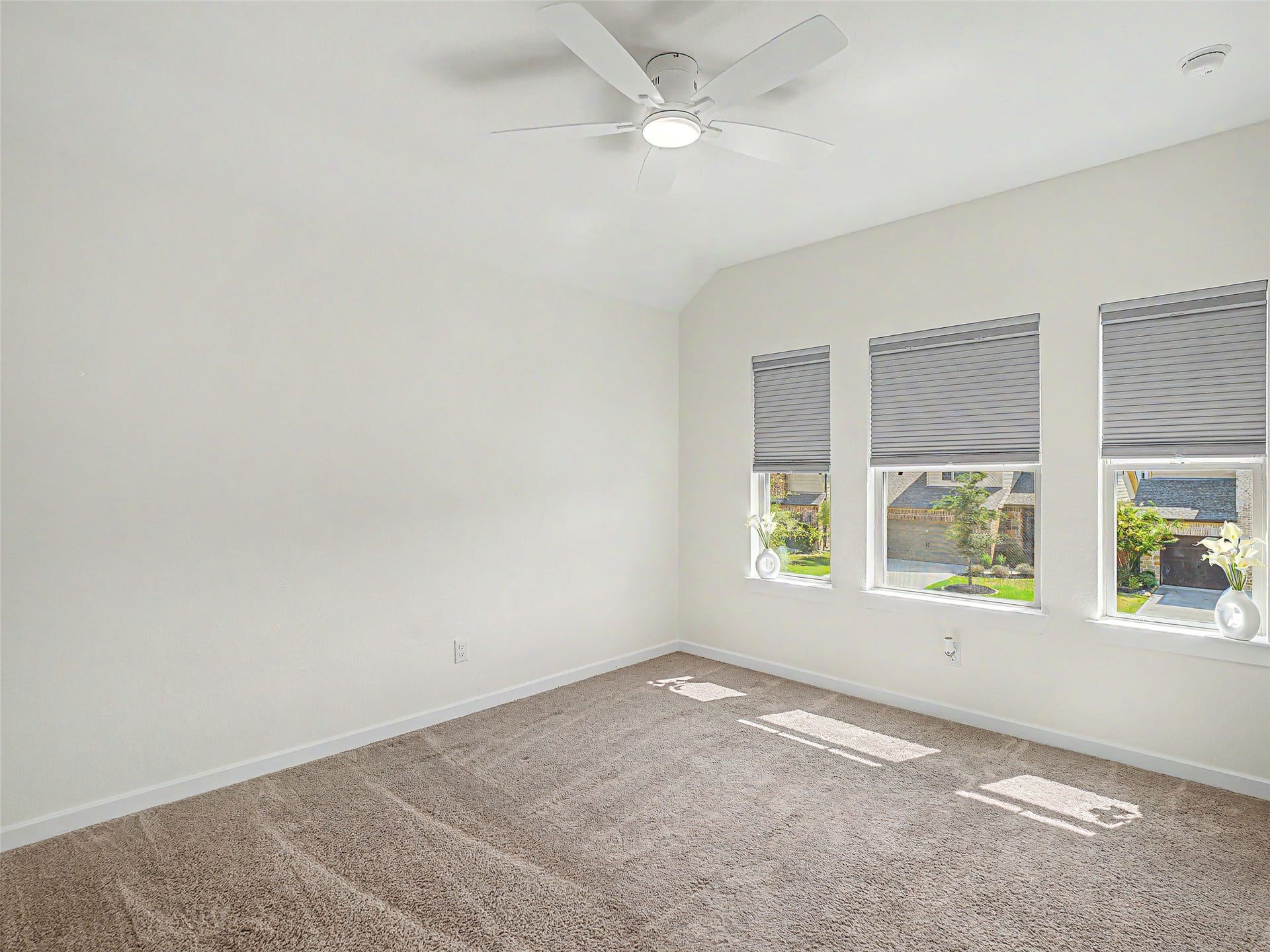 6019 Dovetail Cliff Court, Katy, TX 77493 This bright upstairs bedroom features a trio of large front-facing windows that flood the room with natural light and offer peaceful street views. With its spacious layout and vaulted ceiling line, this room works perfectly as a cozy guest suite, children's bedroom, or dedicated private home office.