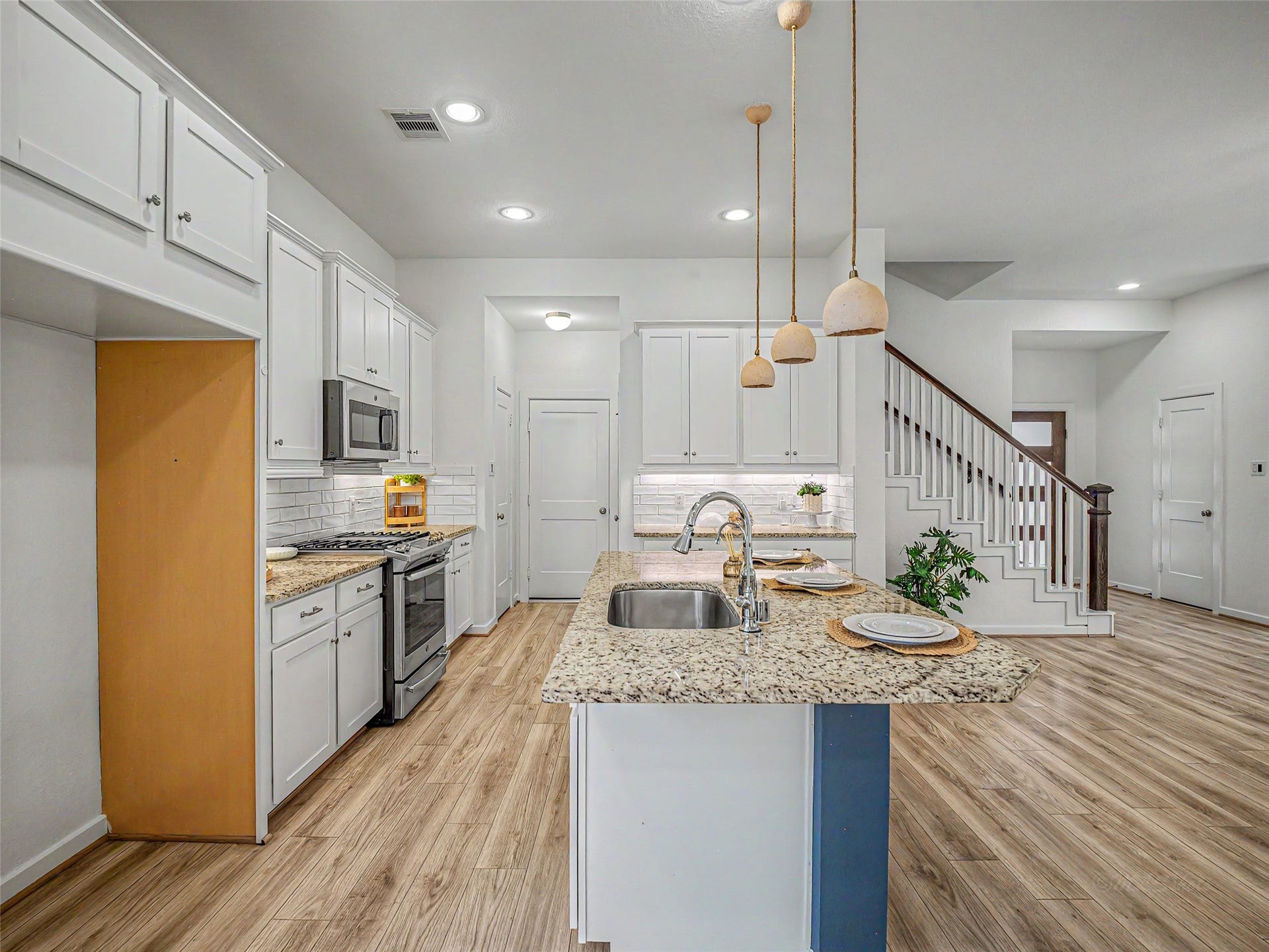 6019 Dovetail Cliff Court, Katy, TX 77493 This chef-inspired kitchen features a center island with a granite countertop, a built-in stainless steel undermount sink, and a high-arc gooseneck faucet with a pull-down sprayer.