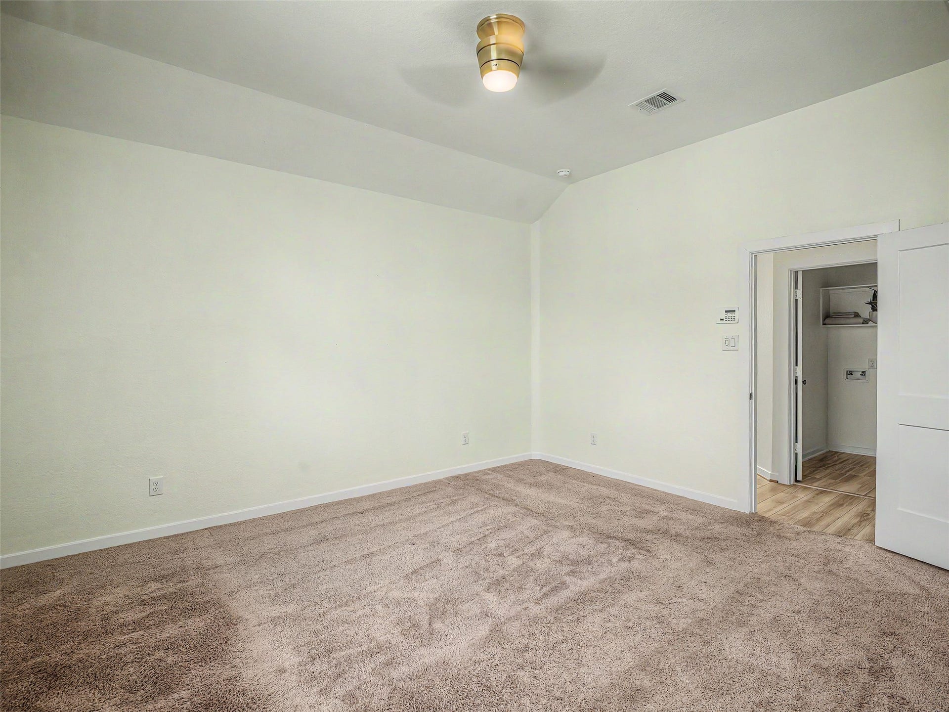 6019 Dovetail Cliff Court, Katy, TX 77493 Another view of the primary bedroom highlights its exceptional space, showing the room's high vaulted ceiling angles, crisp white walls, and soft carpet.