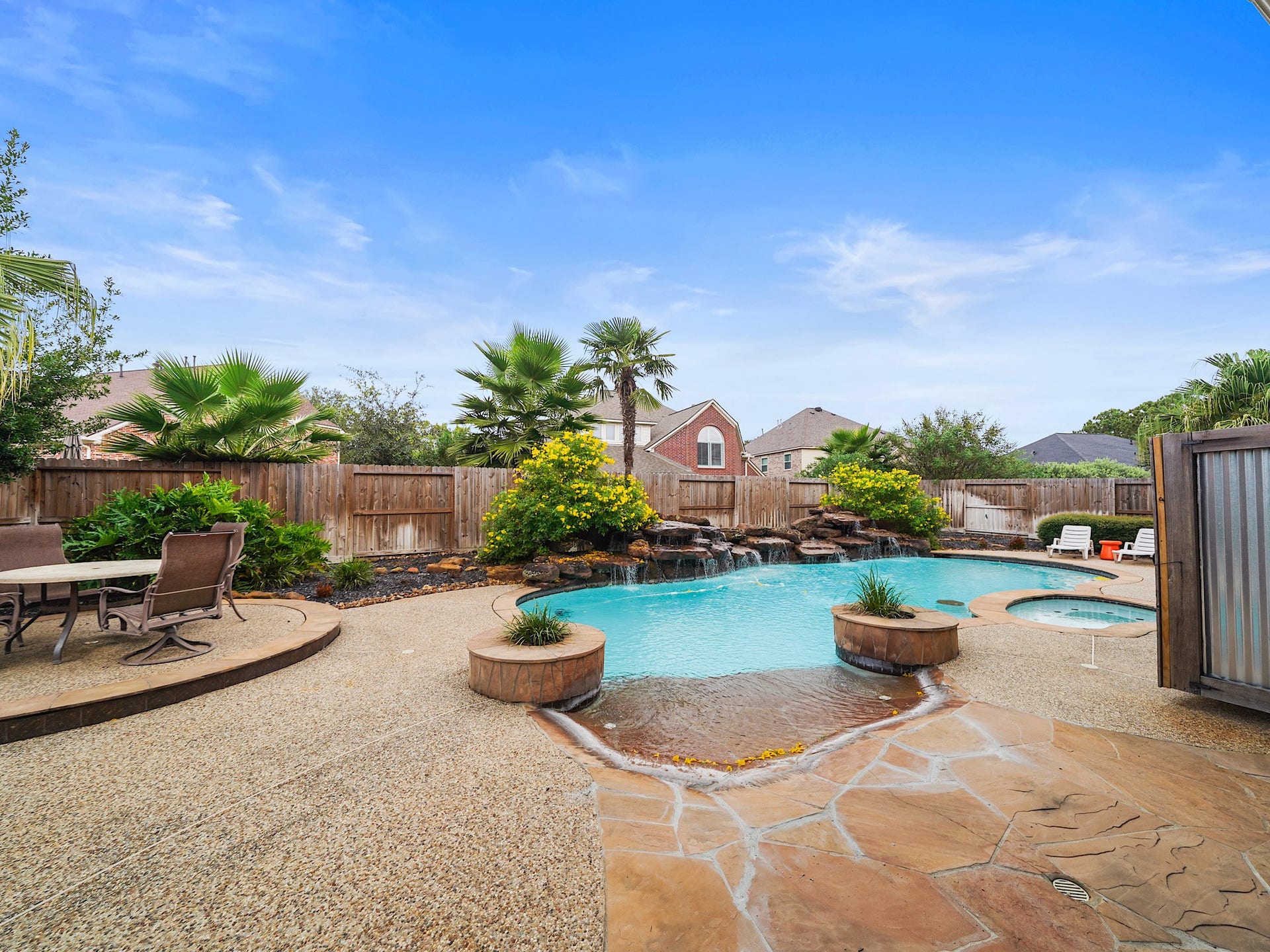 25610 Skye Springs Lane, Katy, TX 77494 Wide patio surrounds and a sculpted pool-and-spa design make this backyard ready for lounging, play, and gathering under the open sky.