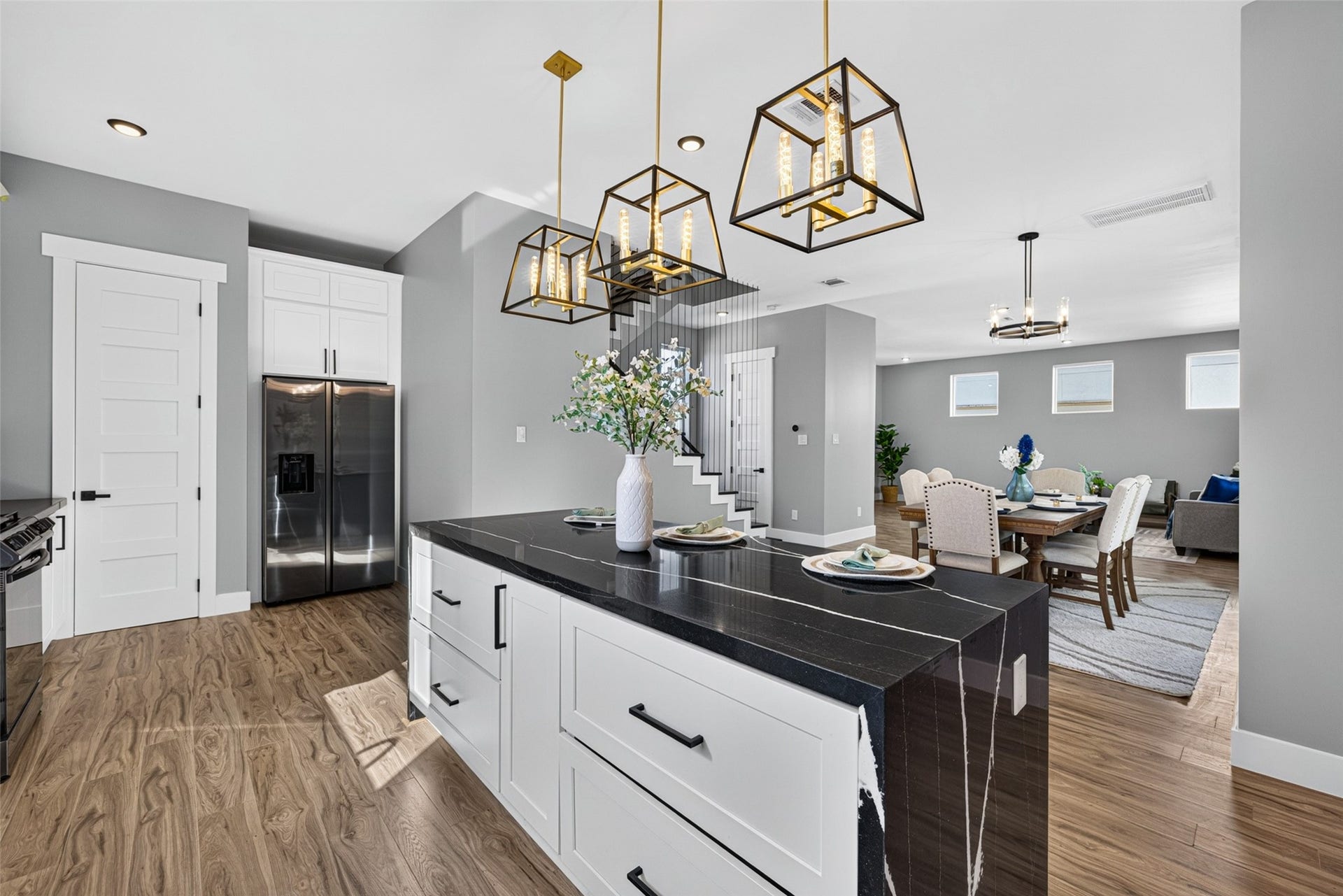 Chic pendant lighting overhead casts a cozy glow across the open space, keeping you connected to the surrounding living and dining areas.