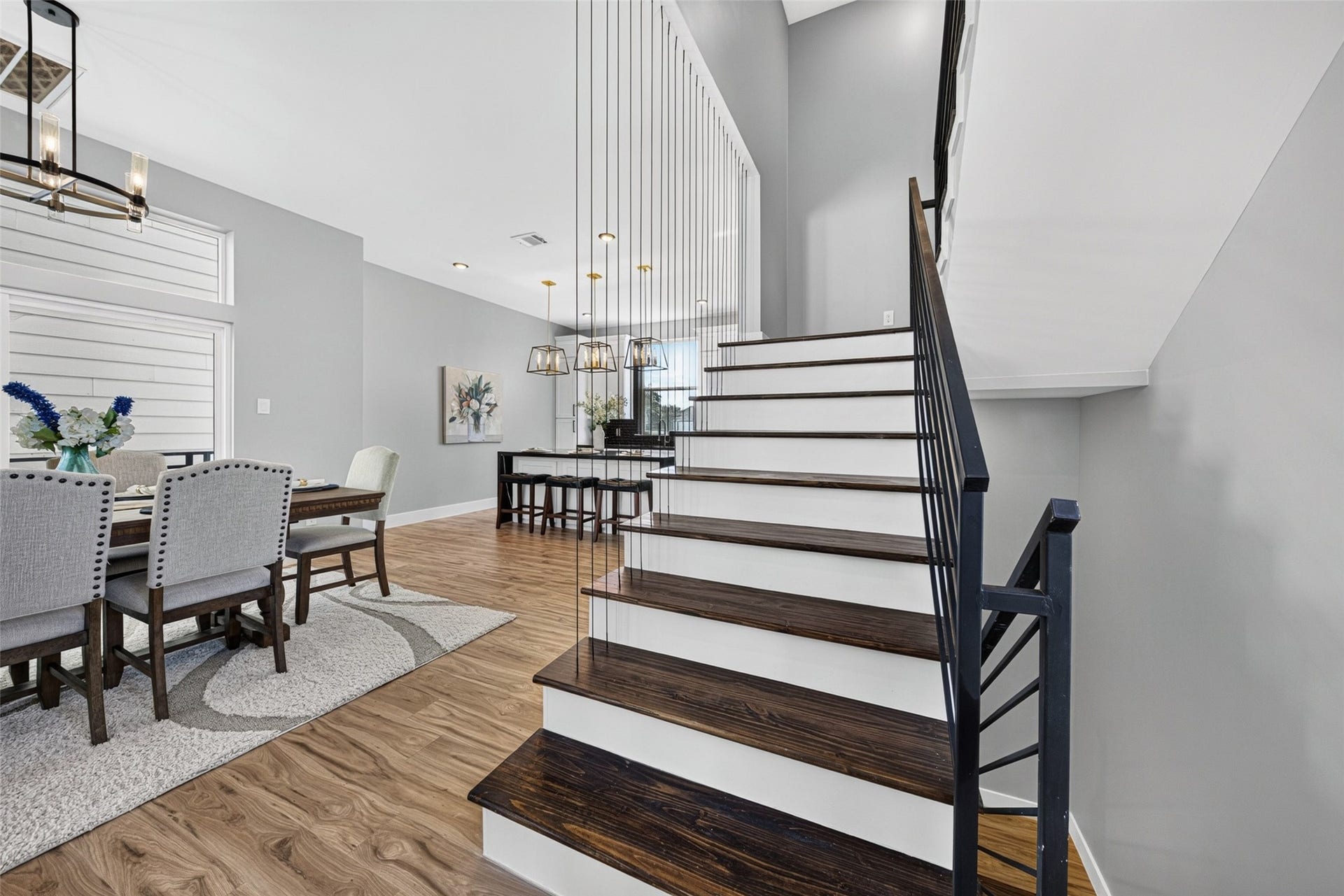 View of the dining area and staircase leading up to the third-level private bedrooms.