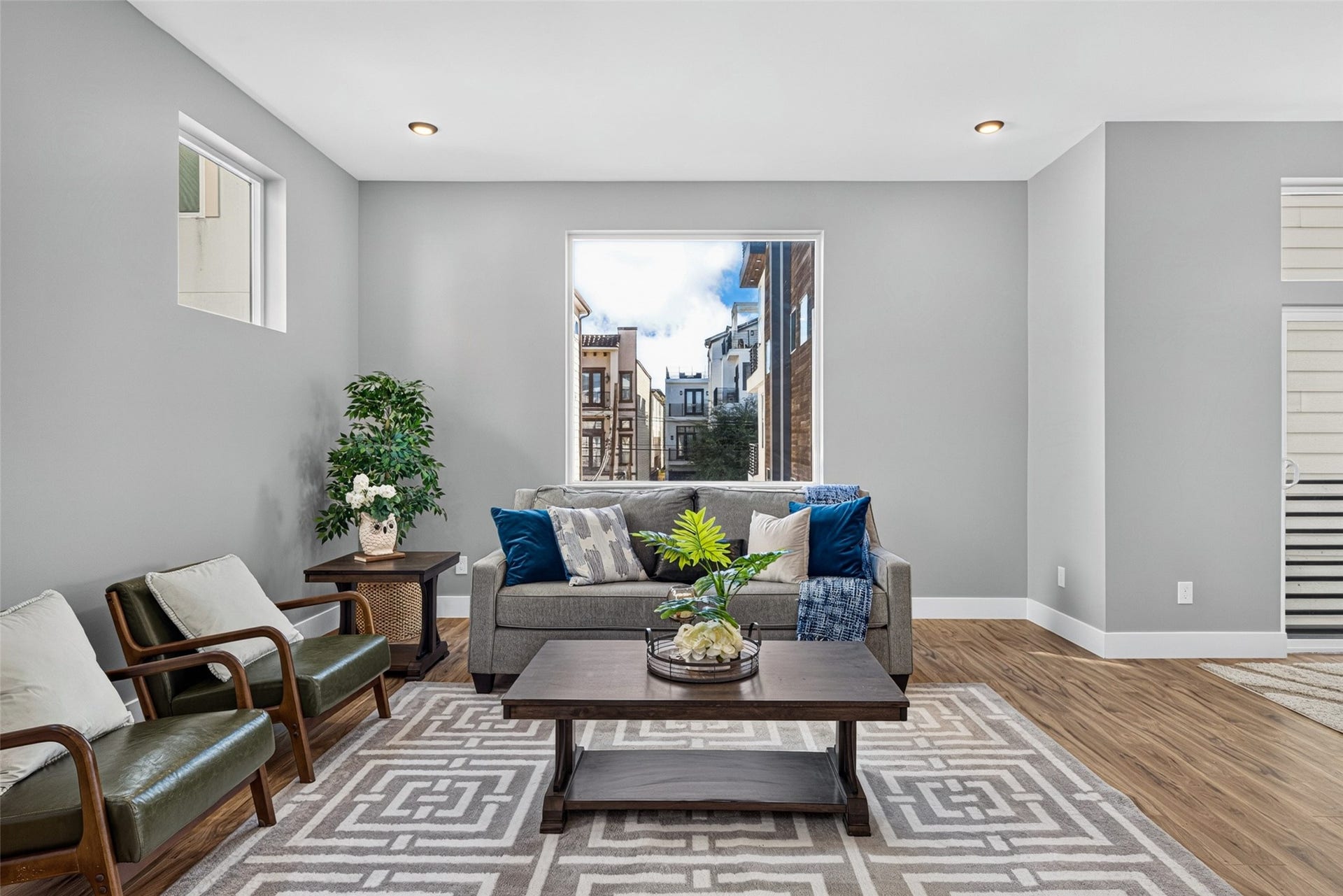 Beautiful hardwood floors and large windows fill the space with warmth and natural light, creating a cozy, inviting atmosphere.