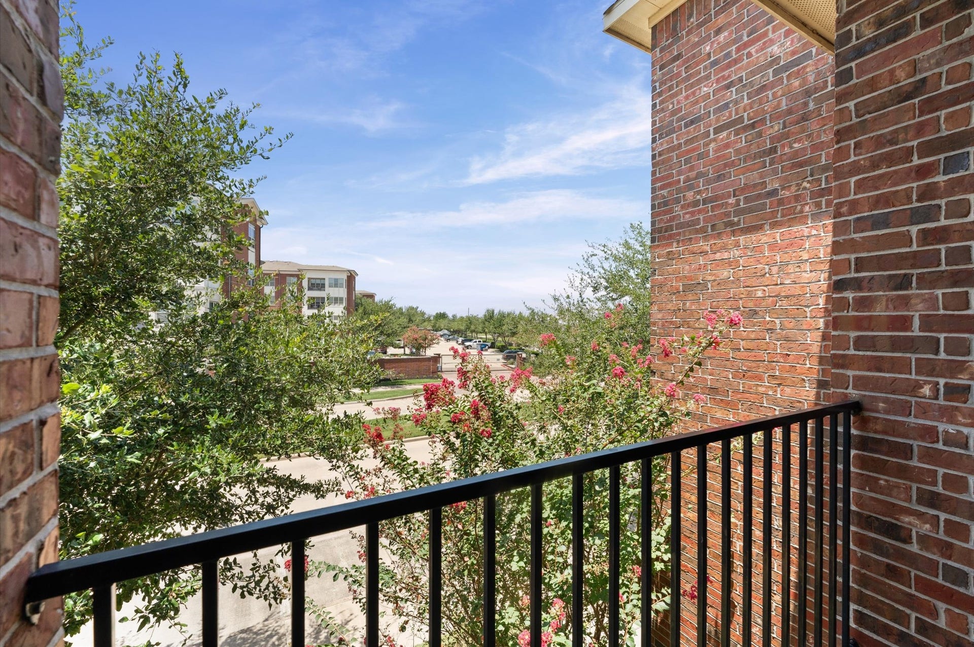 118 Stadium Drive, Sugar Land, TX 77498 Charming balcony offers a serene view of lush greenery and vibrant blooms, perfect for enjoying peaceful mornings or relaxing evenings.