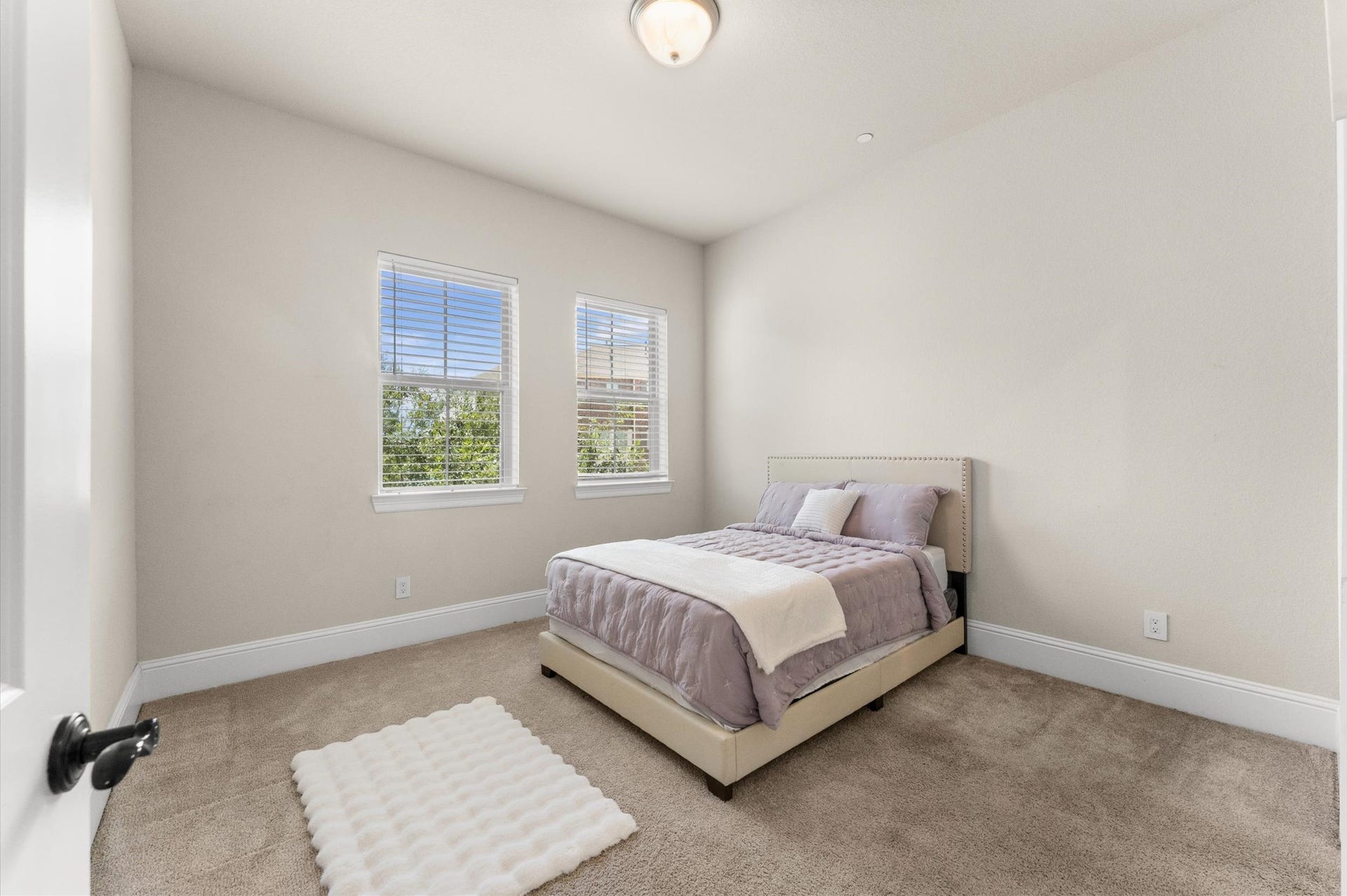 118 Stadium Drive, Sugar Land, TX 77498 Experience tranquility in Bedroom 3, a cozy retreat featuring plush carpeting, soft natural light from dual windows, and a serene ambiance perfect for relaxation.