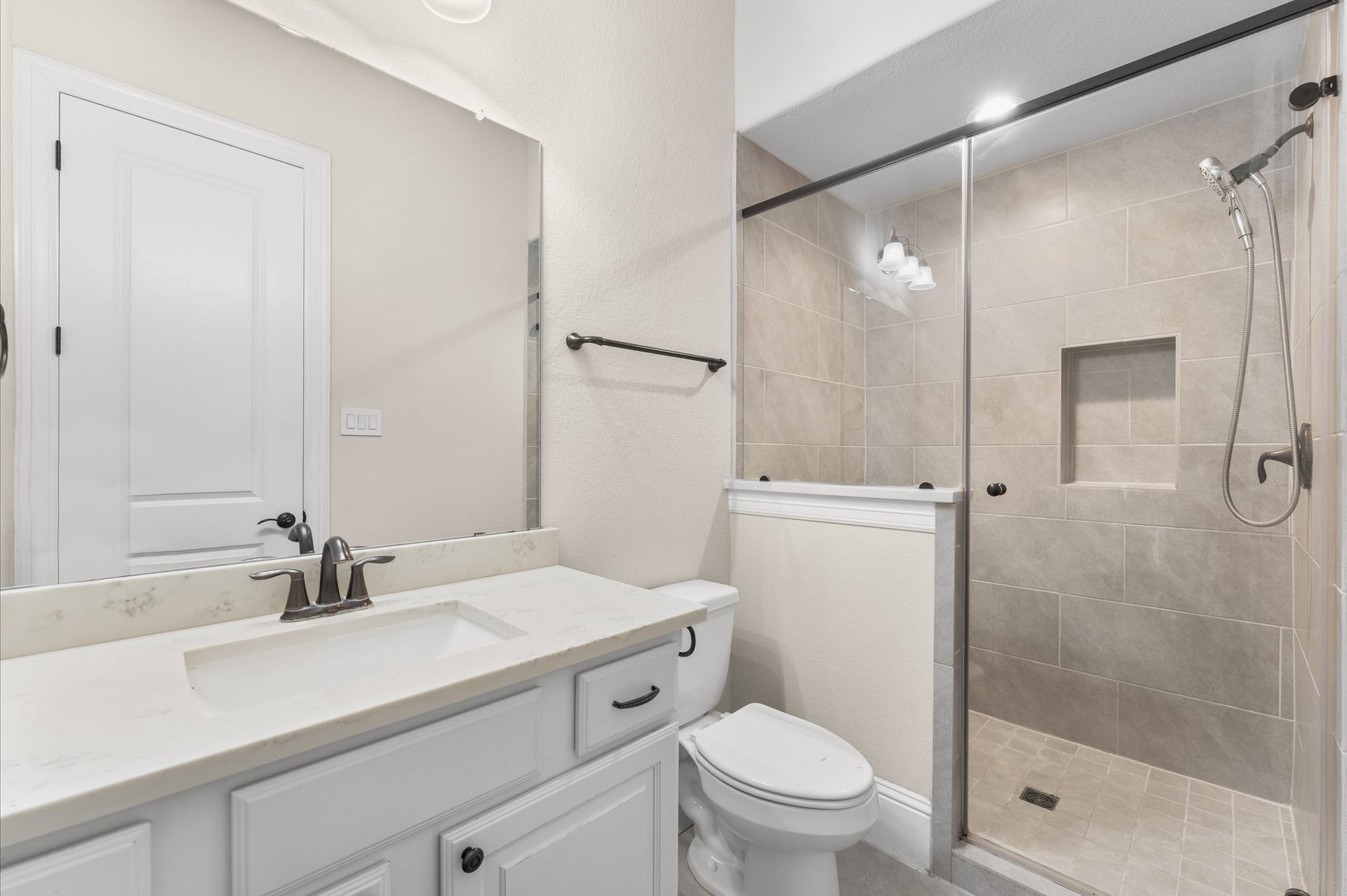 118 Stadium Drive, Sugar Land, TX 77498 Discover the elegance of this on-suite secondary bath, featuring sleek fixtures, a spacious glass-enclosed shower, and a pristine vanity for a touch of luxury.