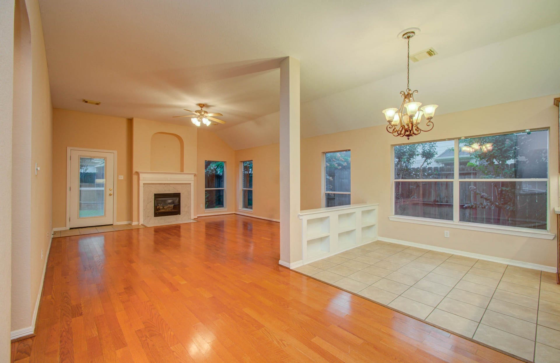 14403 Red Tailed Hawk Lane, Houston, TX 77044 Spacious open-concept living area featuring gleaming hardwood floors, a cozy fireplace, and abundant natural light from large windows.