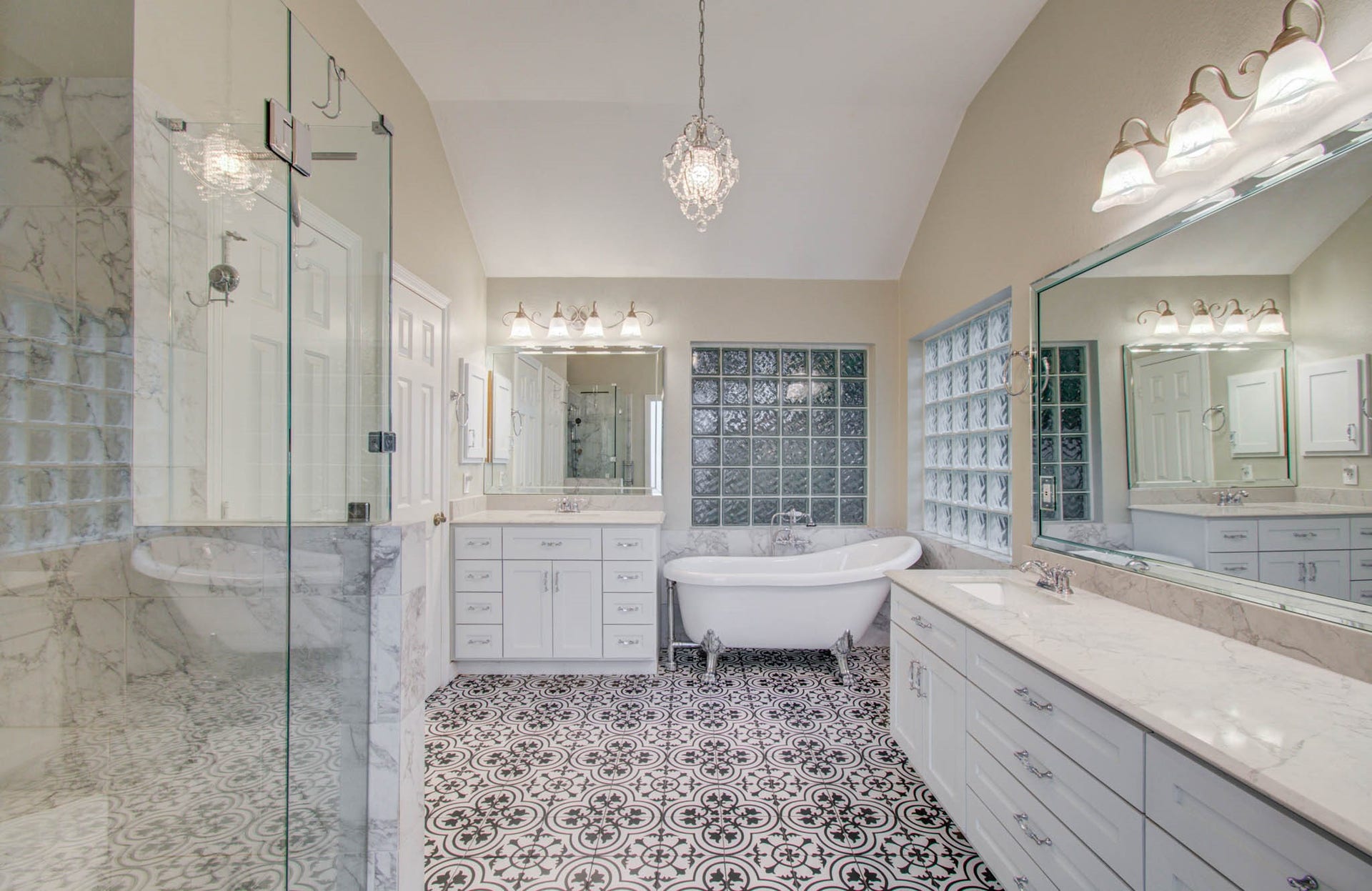 14403 Red Tailed Hawk Lane, Houston, TX 77044 Elegant bathroom featuring a luxurious clawfoot tub, spacious glass-enclosed shower, and stylish patterned tile flooring, all complemented by chic lighting and ample counter space.