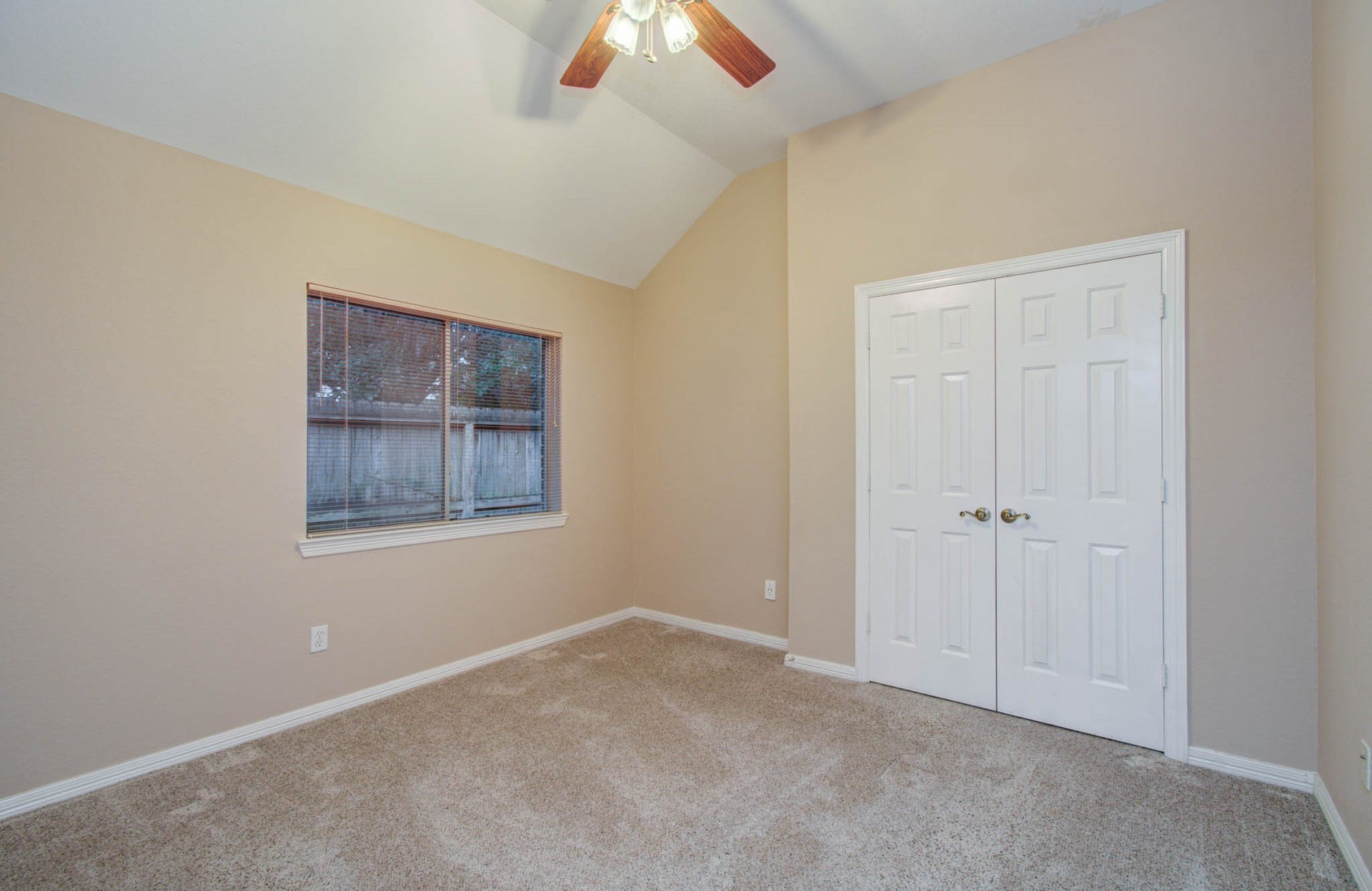 14403 Red Tailed Hawk Lane, Houston, TX 77044 Bright and cozy room featuring a vaulted ceiling, soft carpet, a large window, and a spacious double-door closet.