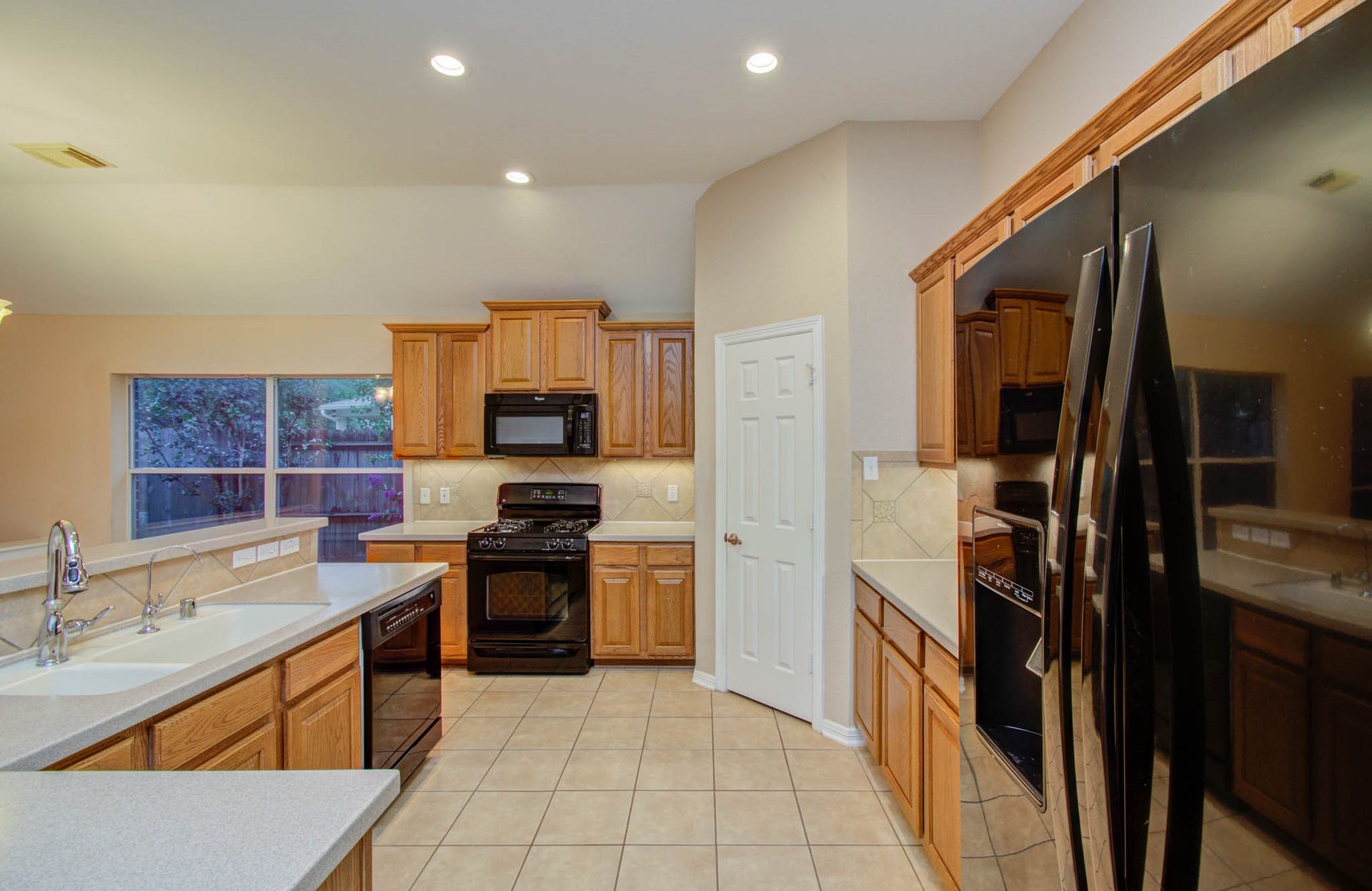 14403 Red Tailed Hawk Lane, Houston, TX 77044 Spacious kitchen with modern appliances, warm wood cabinetry, and ample counter space, perfect for cooking and entertaining.