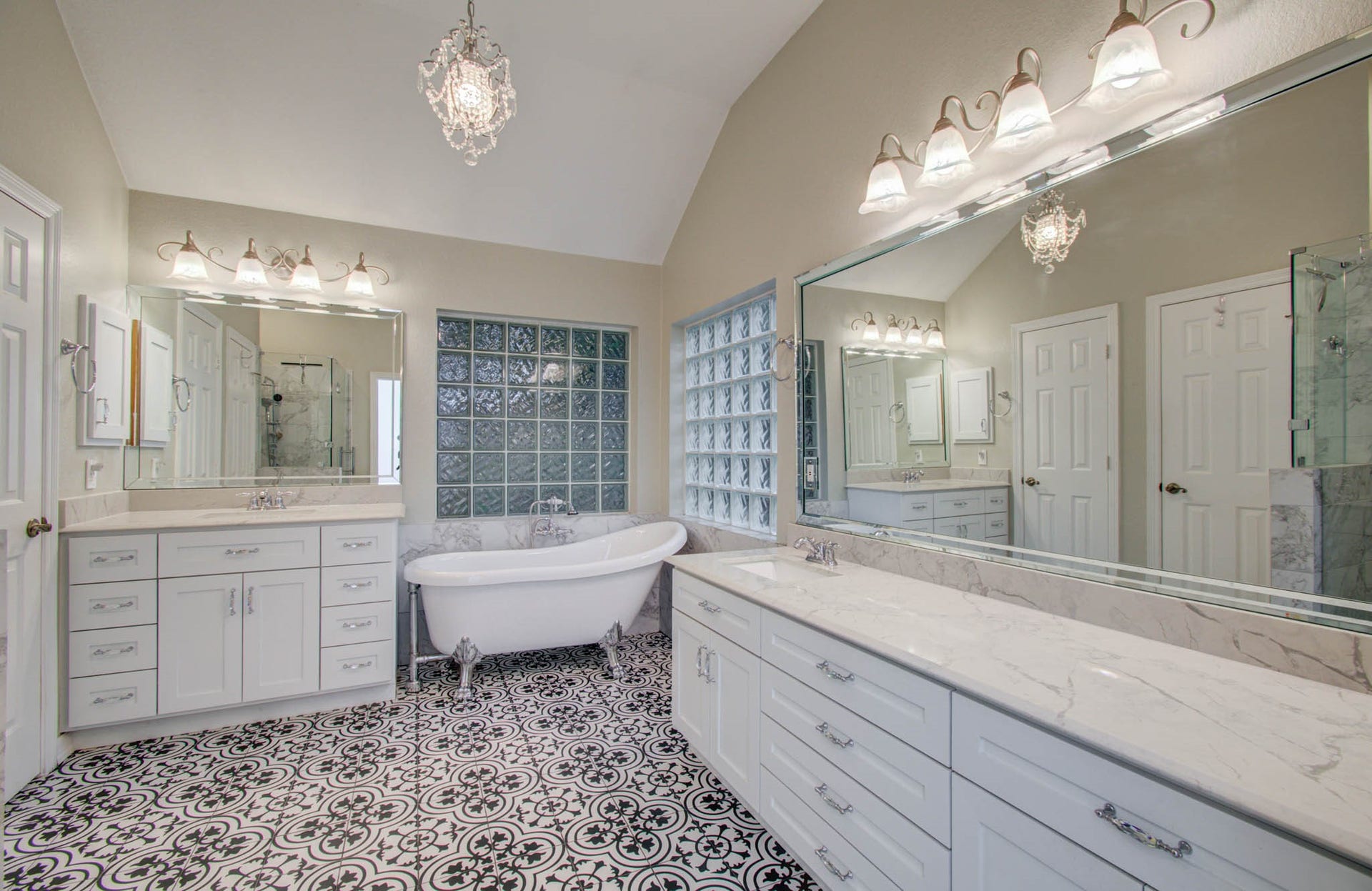 14403 Red Tailed Hawk Lane, Houston, TX 77044 Elegant bathroom featuring a luxurious clawfoot tub, dual vanities with marble countertops, and chic patterned tile flooring.