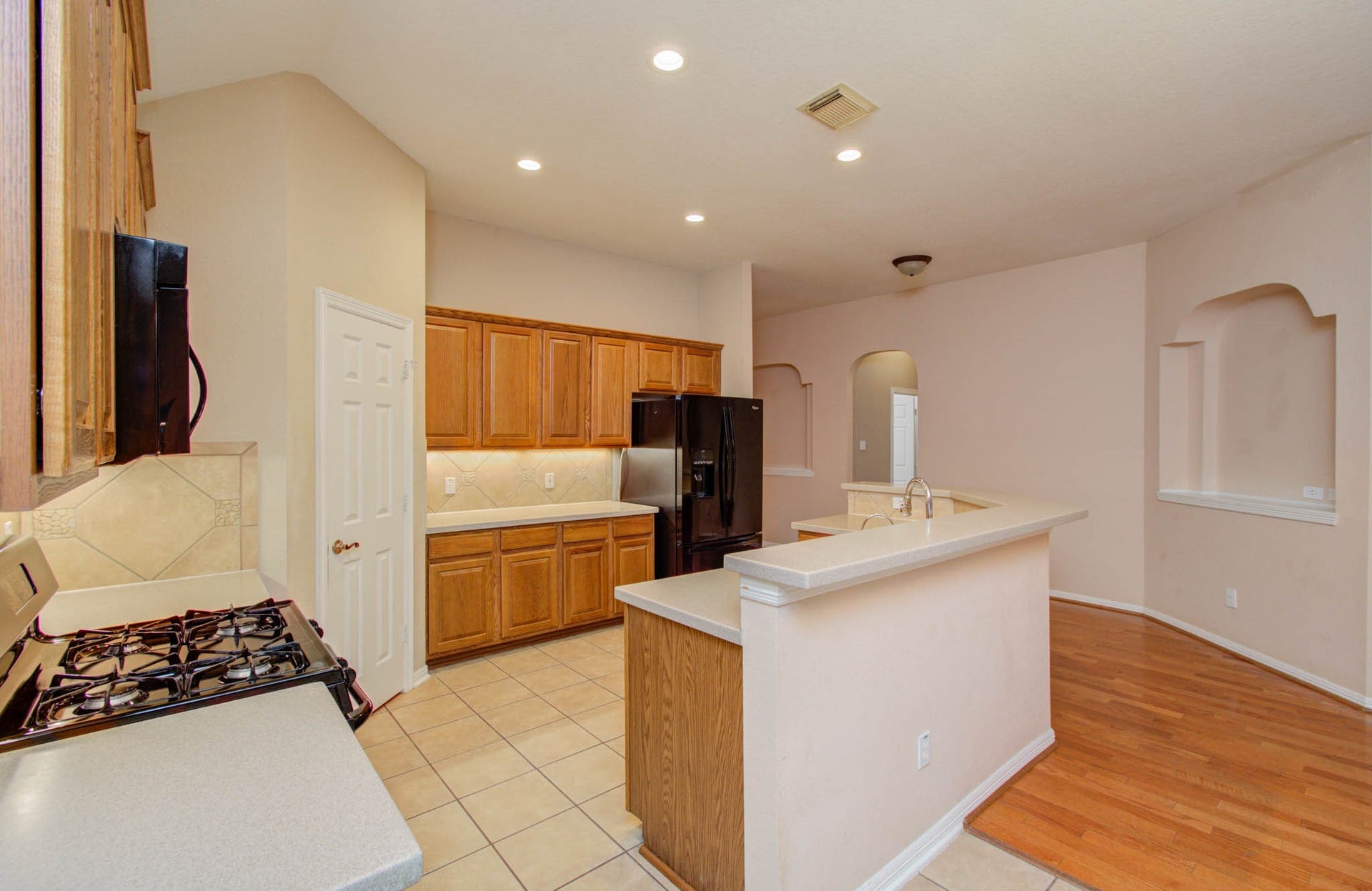 14403 Red Tailed Hawk Lane, Houston, TX 77044 Bright and spacious kitchen with modern appliances, ample cabinetry, and a convenient breakfast bar, seamlessly flowing into an open living area with elegant hardwood flooring.