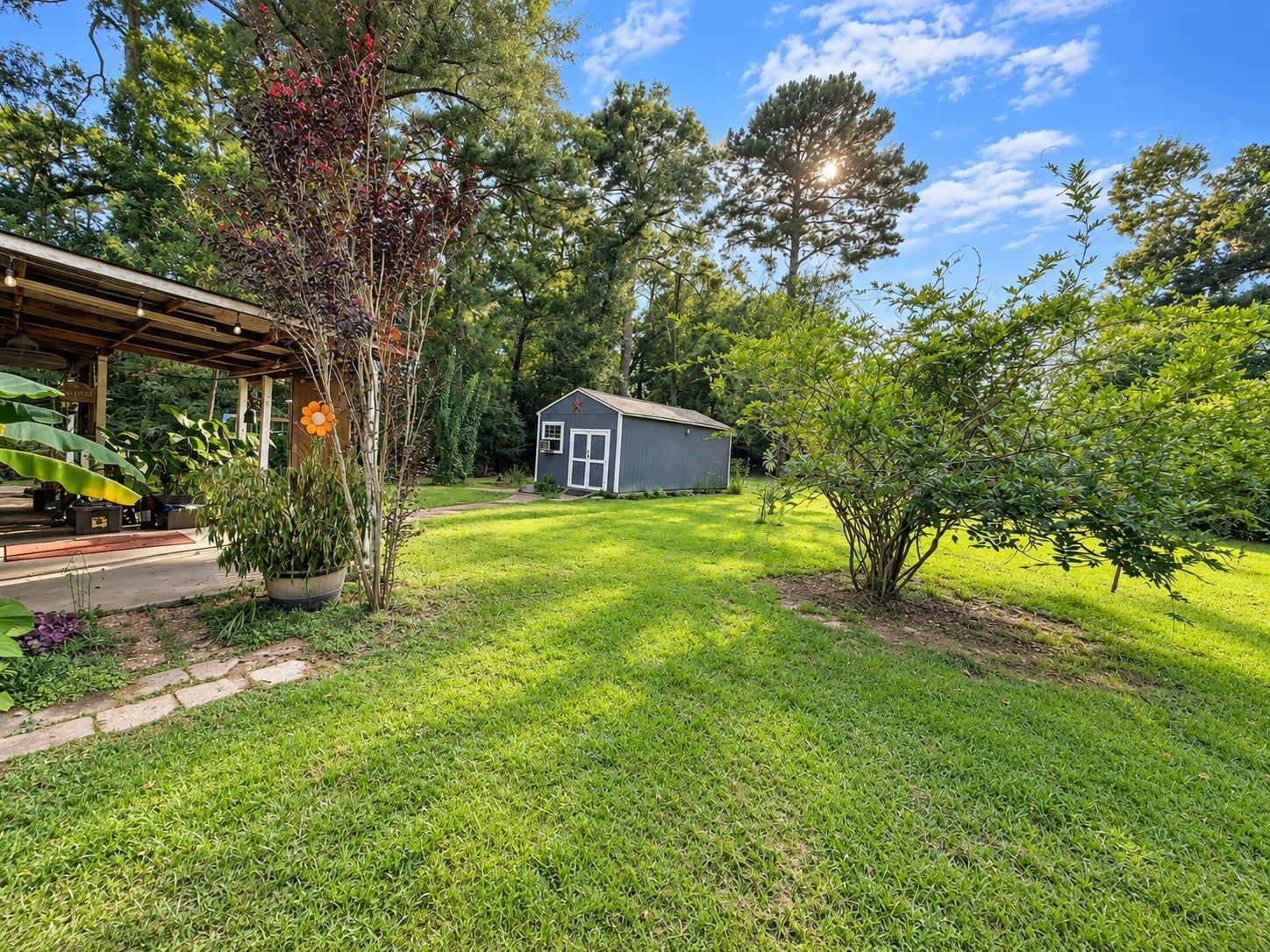 14440 Lakecrest Drive, Splendora, TX 77372 Backyard & Storage Building Spacious backyard with mature landscaping, covered outdoor area and detached storage building.