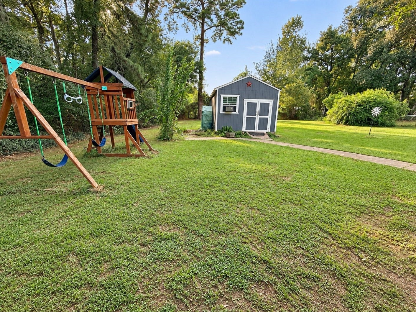 14440 Lakecrest Drive, Splendora, TX 77372 Back Yard Storage:
Spacious backyard featuring a storage building, mature trees, and lush green lawn.