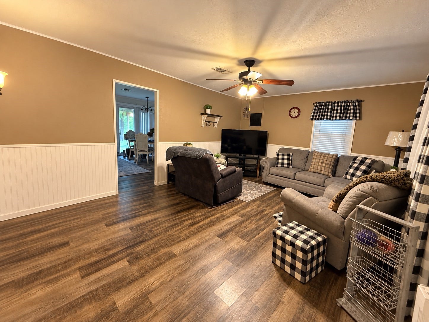 14440 Lakecrest Drive, Splendora, TX 77372 Living Room Spacious living room featuring wood-look flooring, wainscoting, ceiling fan and abundant natural light.
