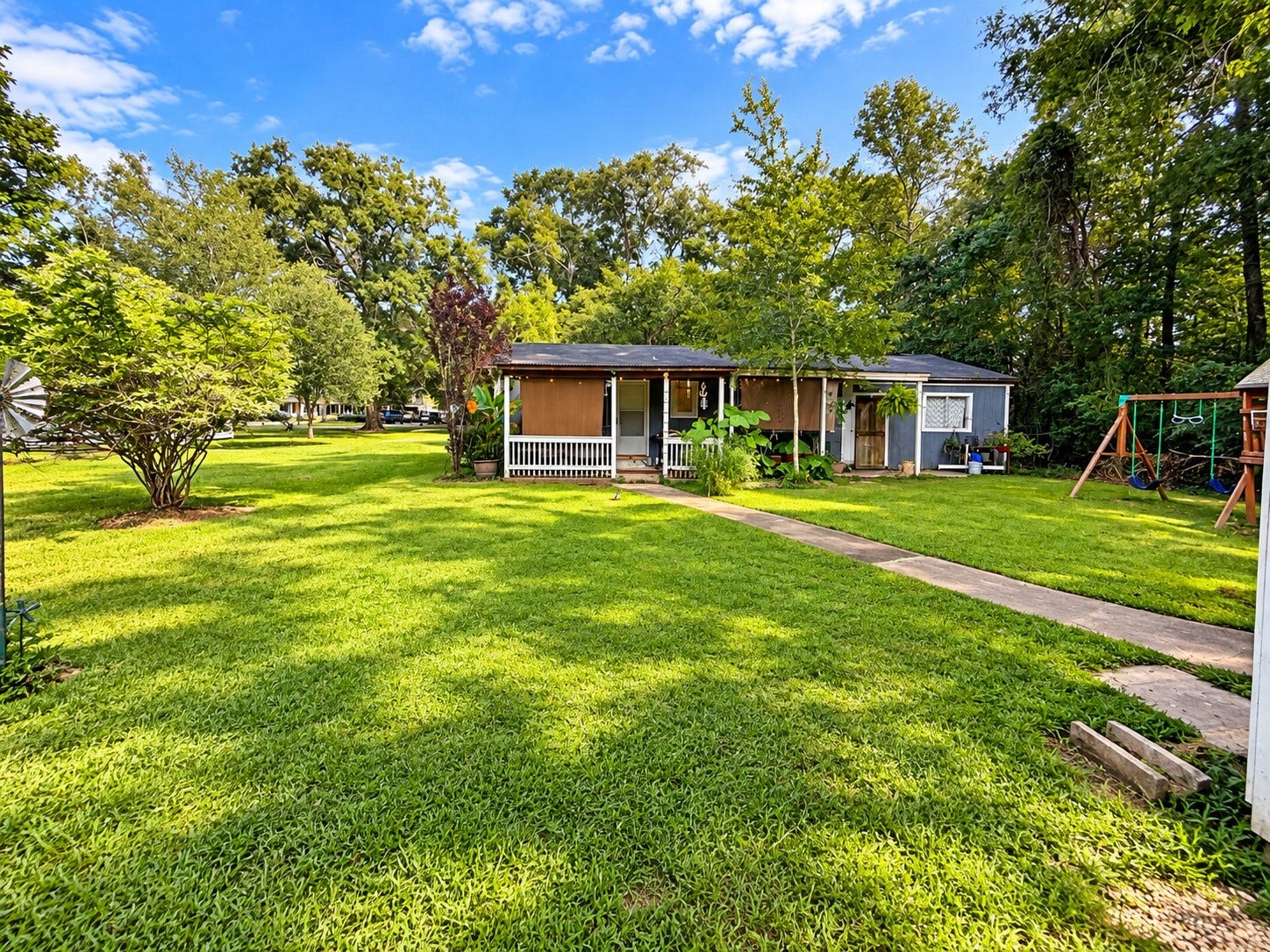14440 Lakecrest Drive, Splendora, TX 77372 Back House:
Back Exterior: Large backyard with mature trees, expansive grassy area, covered patio space, walkway, and play area.