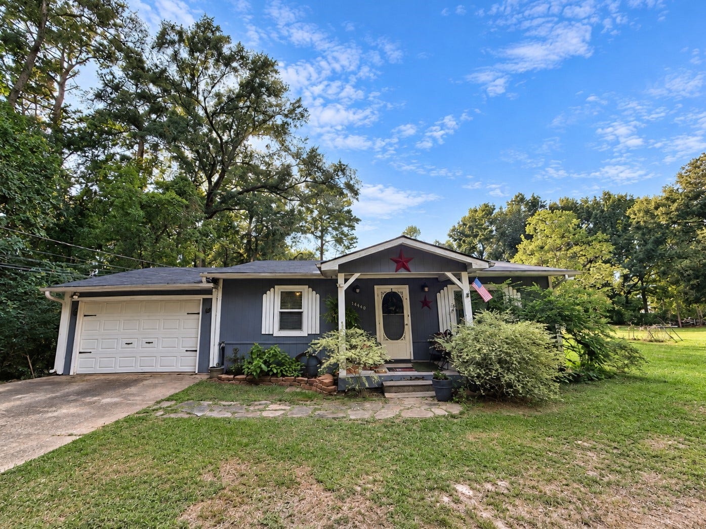 14440 Lakecrest Drive, Splendora, TX 77372 Front Exterior: Charming single-story home with inviting covered entry, attached garage, mature landscaping, and spacious front yard.