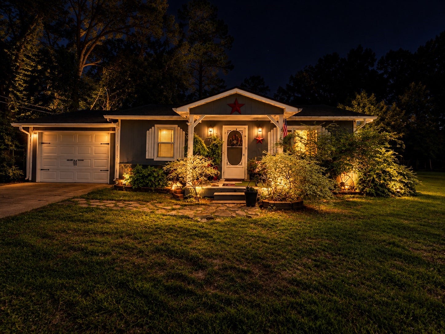14440 Lakecrest Drive, Splendora, TX 77372 Front Exterior Night: Beautifully illuminated front exterior showcasing the covered entry, mature landscaping, and warm evening curb appeal.