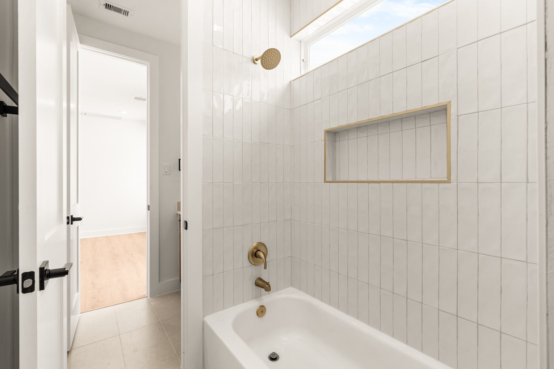 Refreshing secondary bath featuring a deep soaking tub and custom vertical tile surround.
