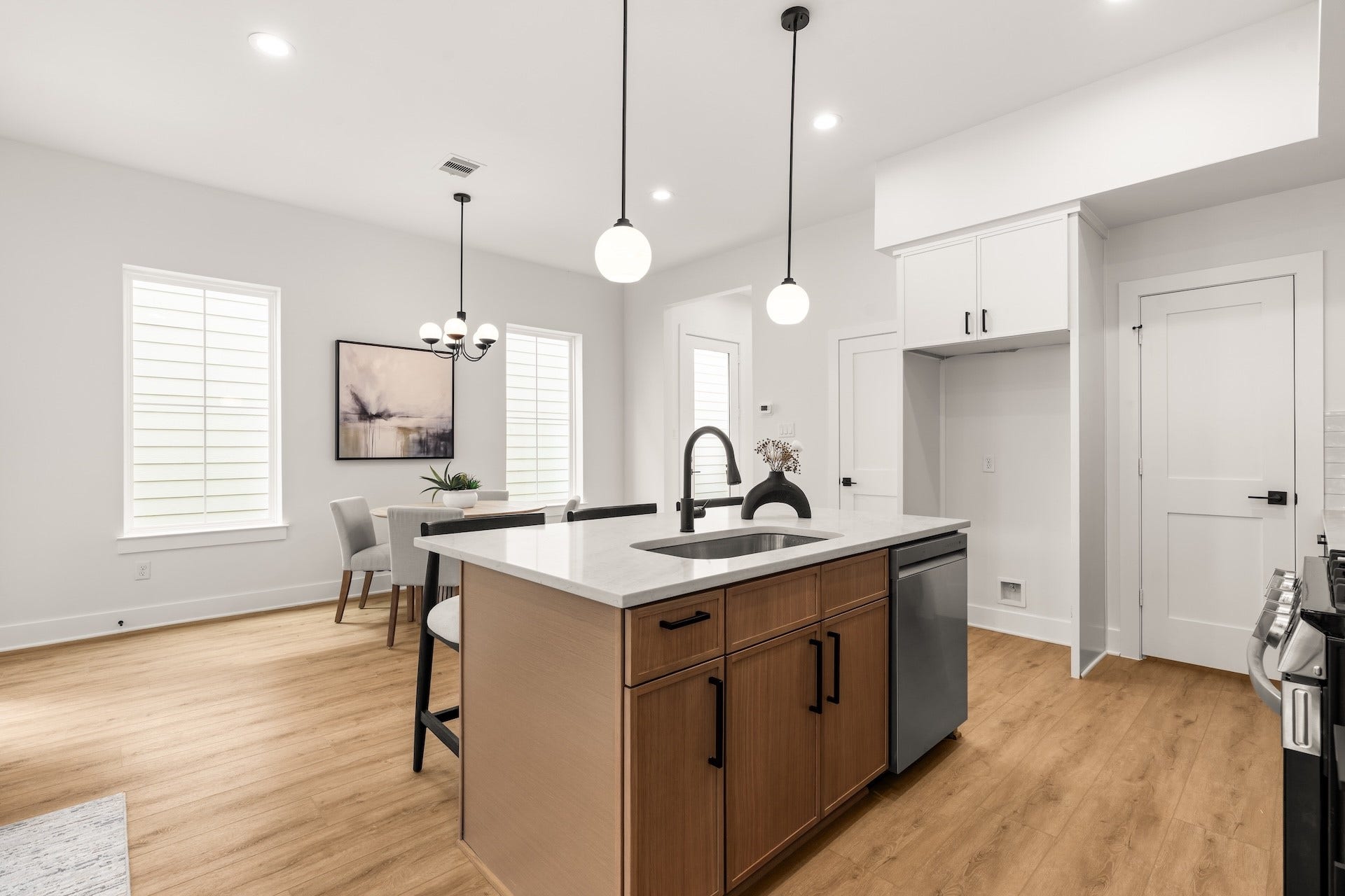 Open-concept layout offering effortless flow between the kitchen, central dining, and main living areas.