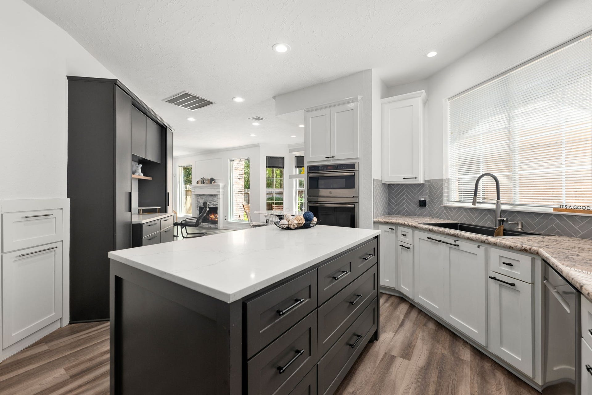 26 Cinnamon Teal Place, The Woodlands, TX 77382 Modern kitchen featuring sleek white cabinetry, stainless steel appliances, and stylish island.