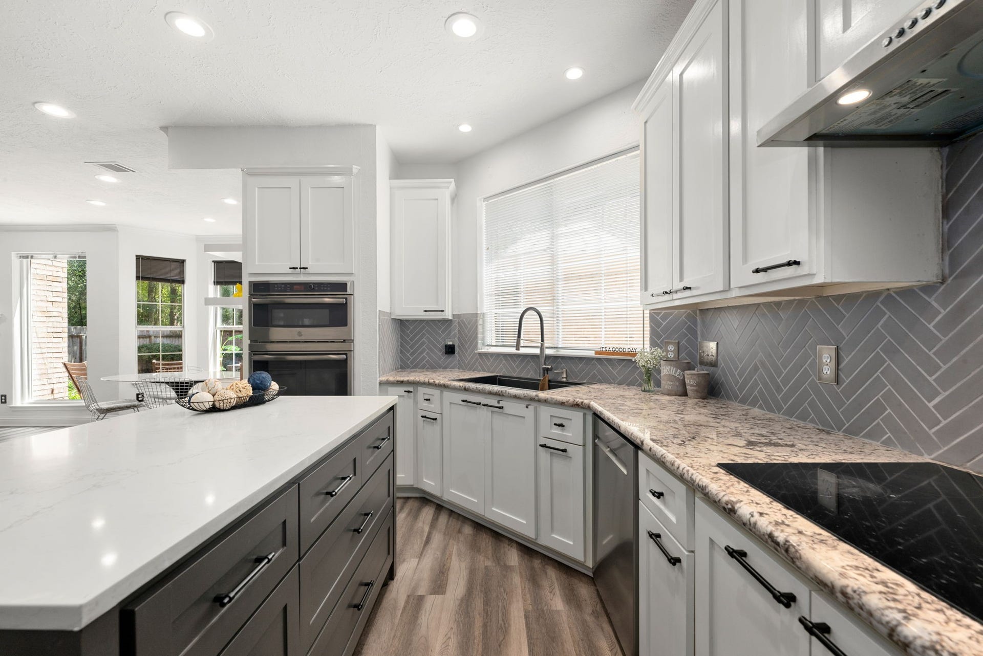 26 Cinnamon Teal Place, The Woodlands, TX 77382 Modern kitchen featuring sleek white cabinetry, stainless steel appliances, and stylish island.