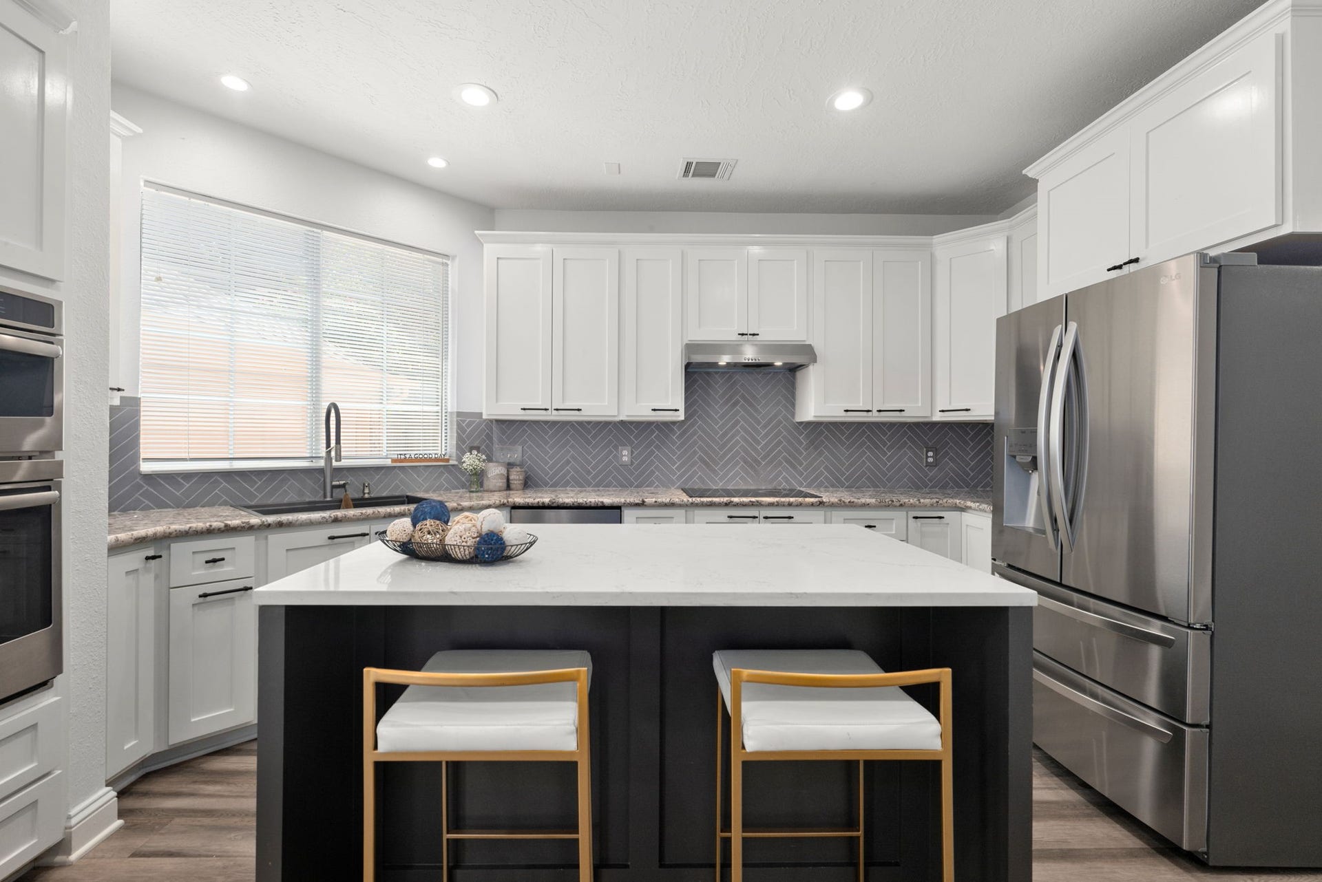 26 Cinnamon Teal Place, The Woodlands, TX 77382 Modern kitchen featuring sleek white cabinetry, stainless steel appliances, and stylish island.