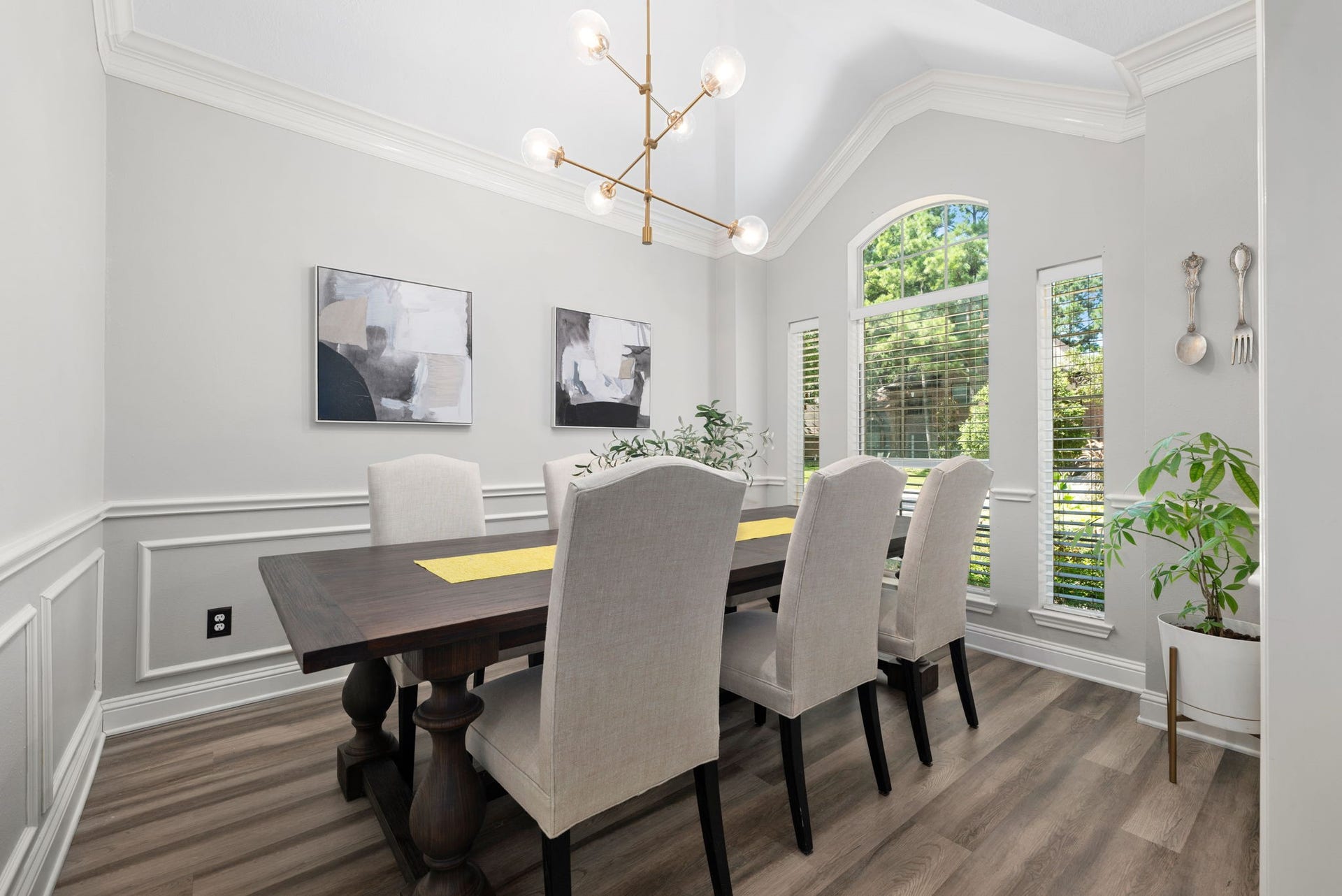 26 Cinnamon Teal Place, The Woodlands, TX 77382 Elegant dining room with a vaulted ceiling, featuring a stylish light fixture, large windows that allow for ample natural light.