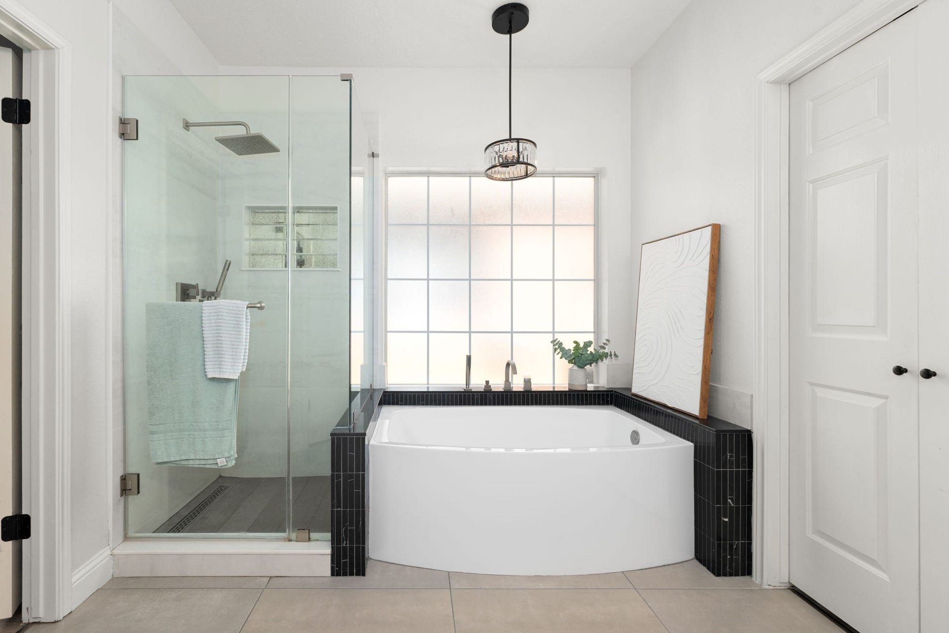 26 Cinnamon Teal Place, The Woodlands, TX 77382 Elegant bathroom featuring a spacious glass-enclosed shower and modern soaking tub.