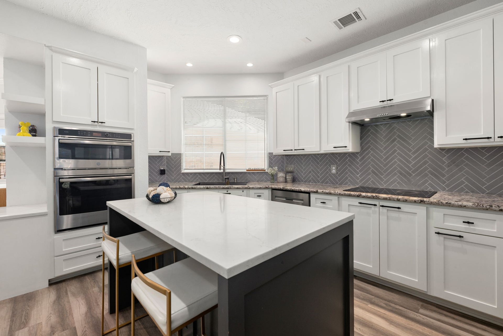 26 Cinnamon Teal Place, The Woodlands, TX 77382 Modern kitchen featuring sleek white cabinetry, stainless steel appliances, and stylish island.