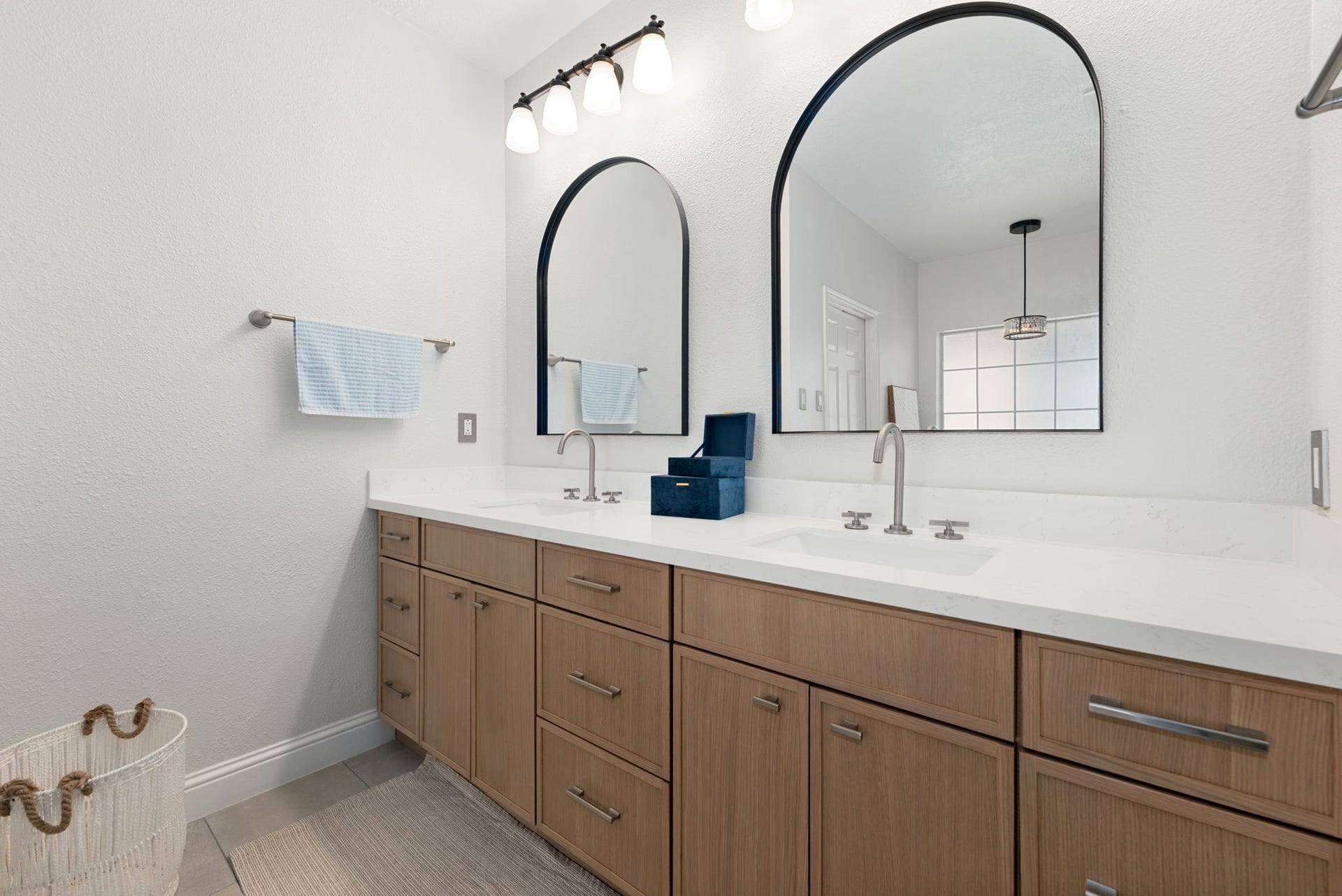 26 Cinnamon Teal Place, The Woodlands, TX 77382 Elegant bathroom featuring a double vanity with sleek quartz countertop, modern fixtures.