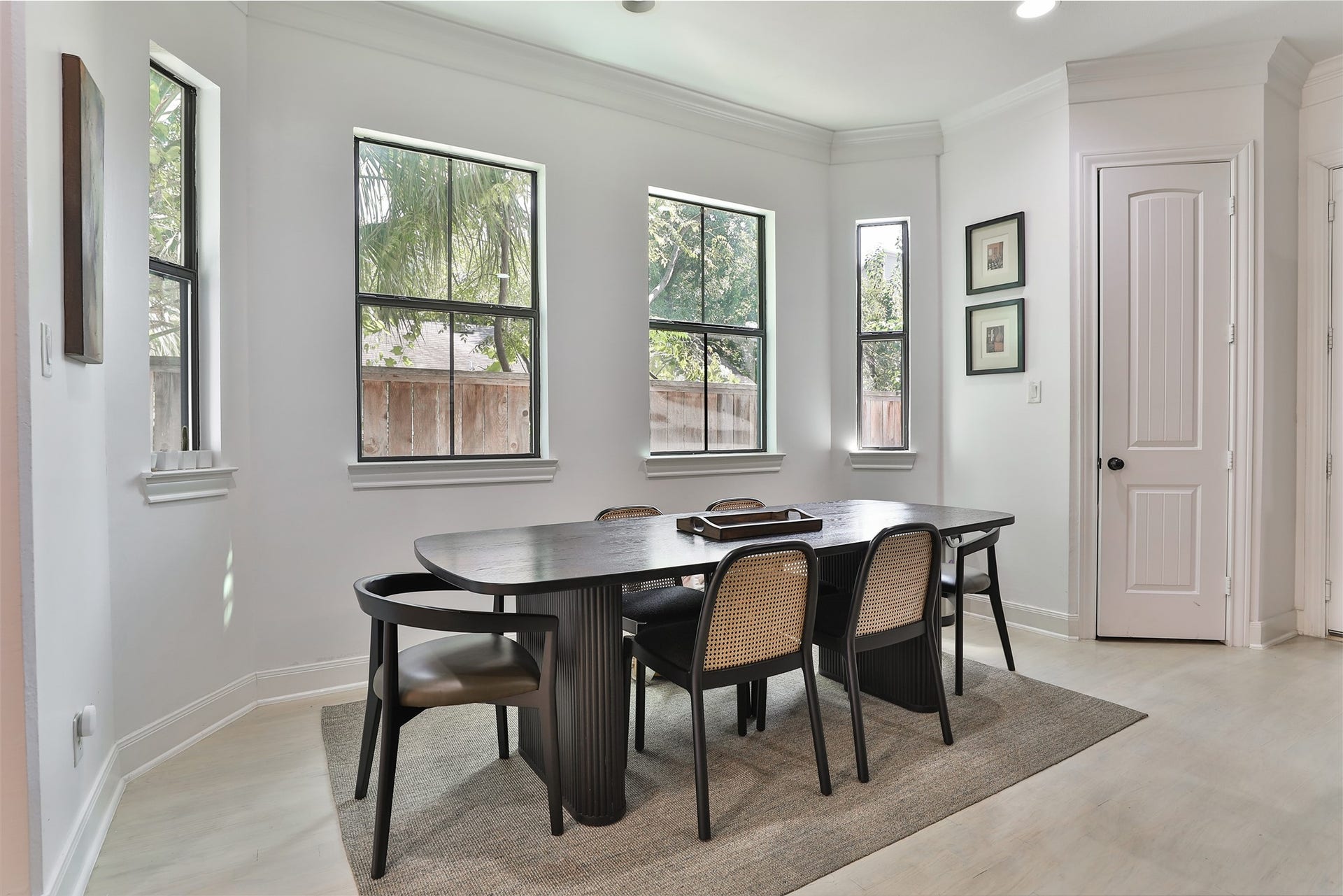 1112 Bingham Street, Houston, TX 77007 Bright and inviting dining area featuring large windows, offering ample natural light and a serene view of lush greenery.